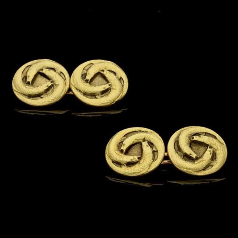 A pair of finely modelled double ended gold cufflinks by Rene Lalique c.1900, each of the four uniform circular terminals with a pattern of three long slender fish circling each other with open mouths, to later rose gold open link fittings. 

18