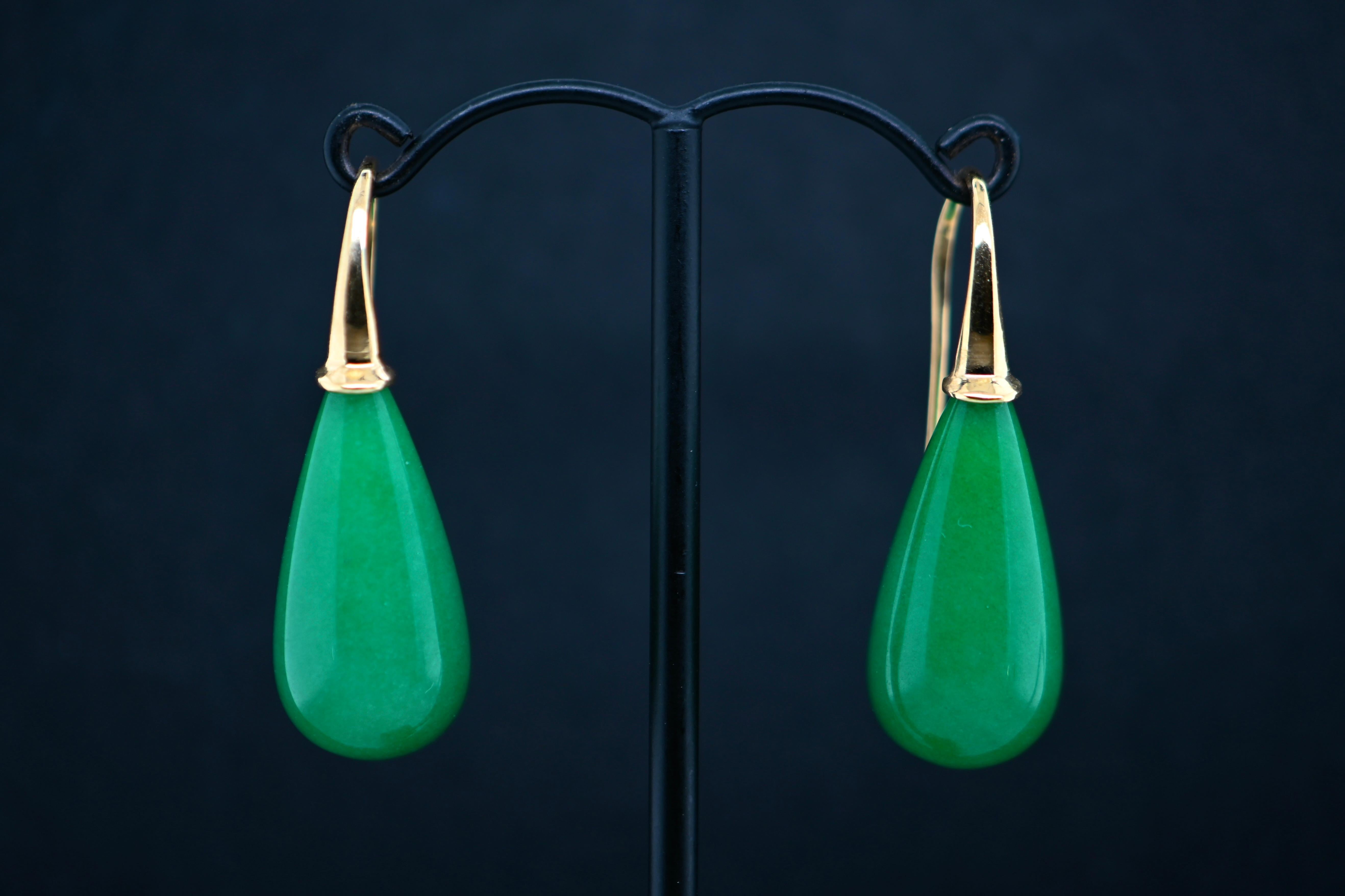 Dive into a realm of luxury with these resplendent drop earrings, where glistening jade stones elegantly dangle from an elaborate framework fashioned in 18-carat gold. Sourced from the verdant landscapes of Malaysia, the jade exudes a captivating
