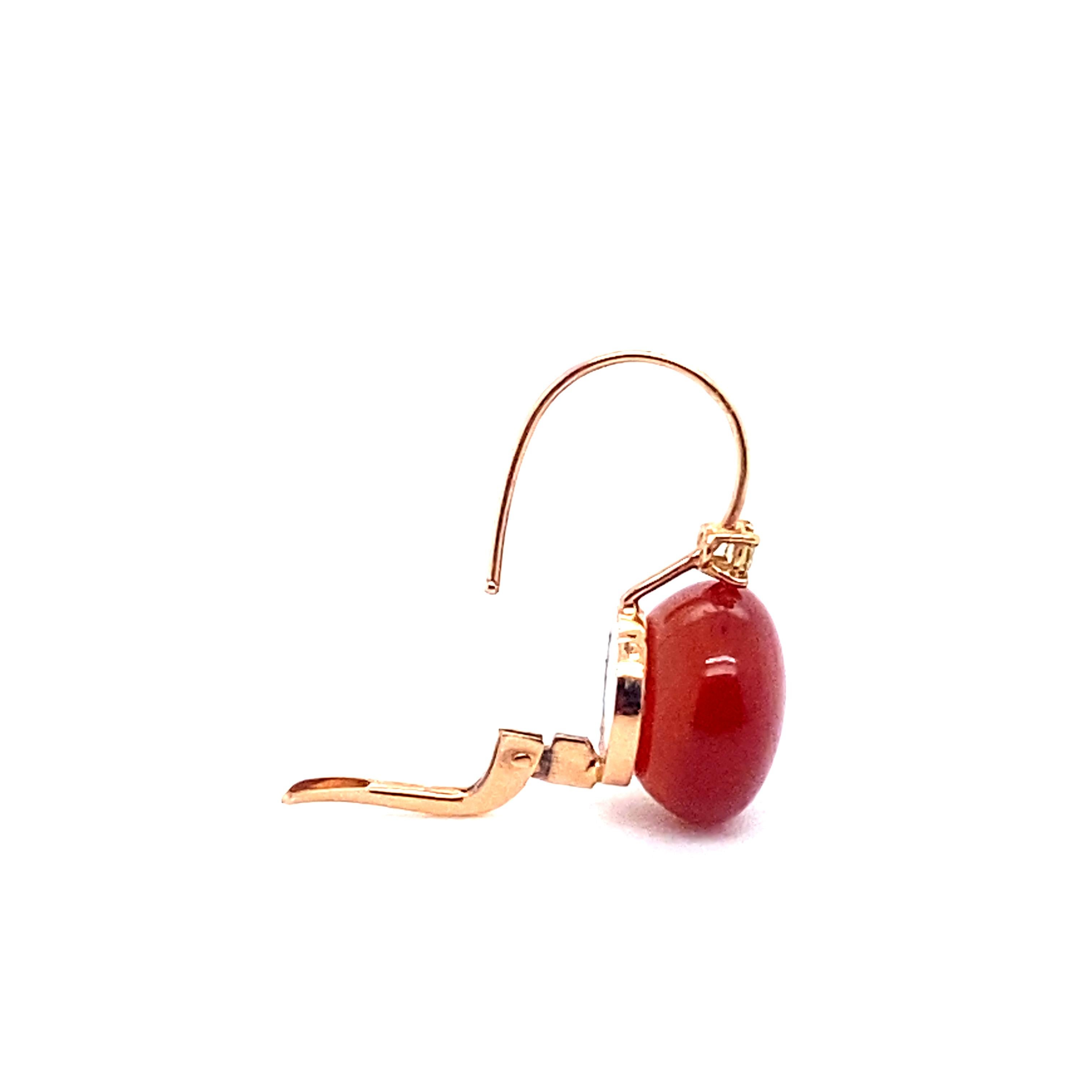 Welcome to our showcase page, where we're delighted to present this sumptuous pair of 18-carat gold earrings, topped with a red agate set with cognac diamonds, and adorned with a delicate mother-of-pearl leaf, an elegant and natural combination that