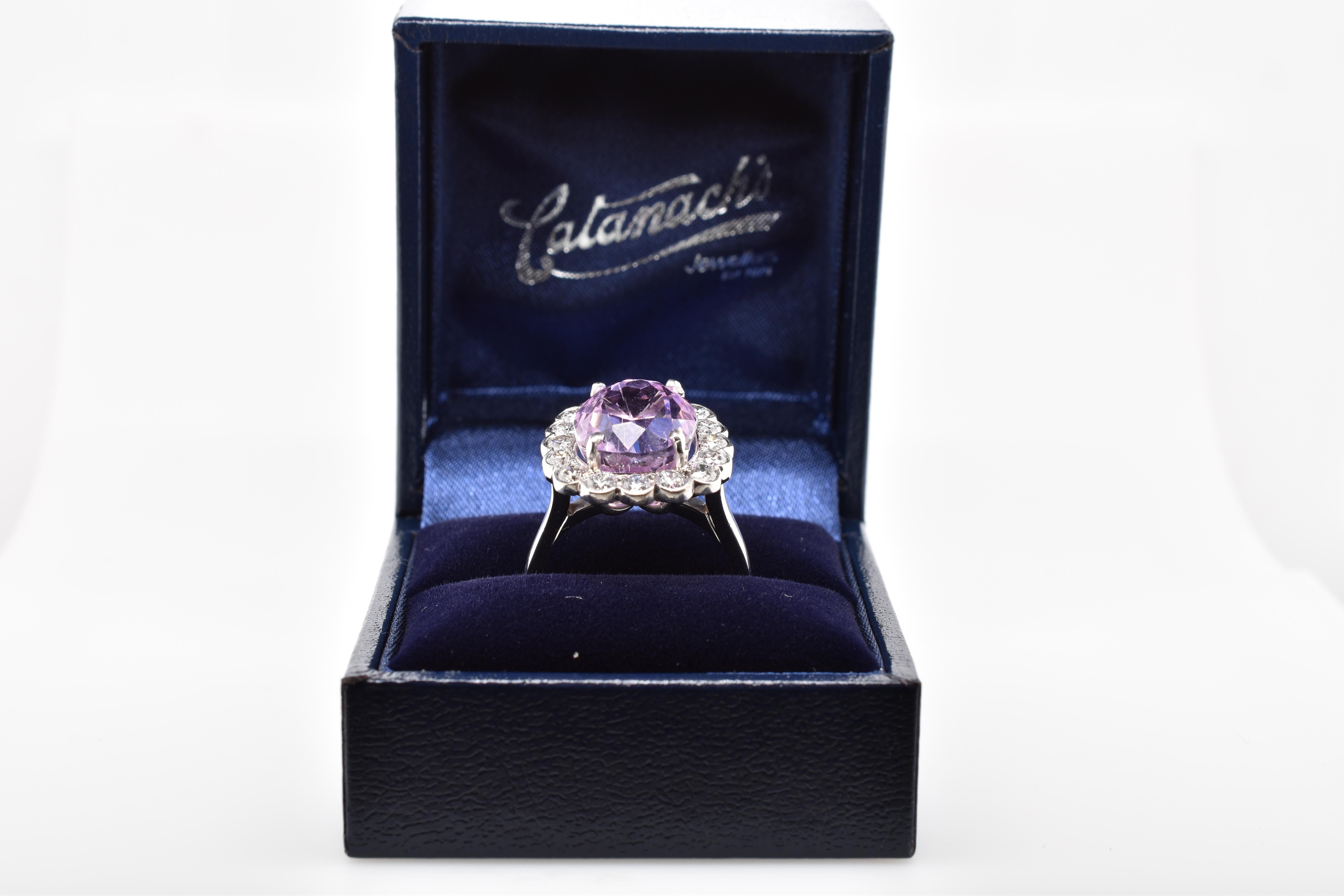 Large oval pink Kunzite and brilliant cut diamonds set in a handmade 18ct white gold scalloped cluster mount. The oval faceted kunzite is a candy pink colour and weighs 9.78ct and is surrounded by 16 round brilliant cut diamonds with a total weight