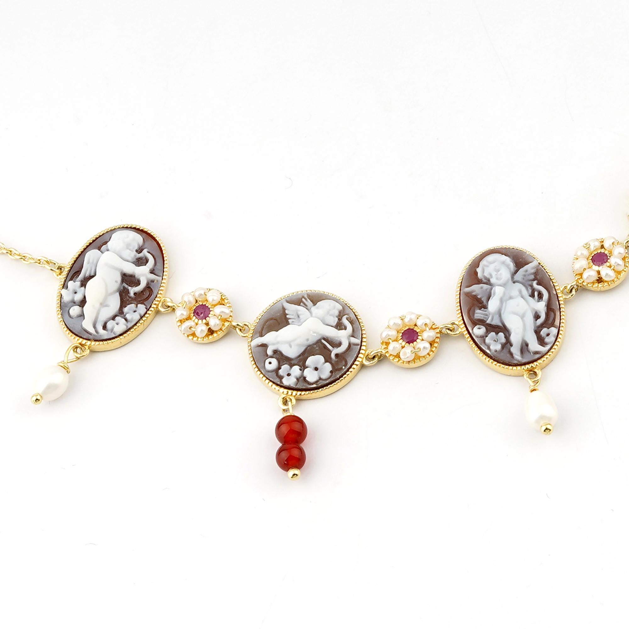 18 carat Gold Plated 925 Sterling Silver with 20mm and 16mm Sea Shell Cameos Bracelet. Fully handcarved Cupids on a sea shell cameo set in a 18kt Gold plated silver Bracelet with red rubies and freshwater pearls. Carvings are performed by our master