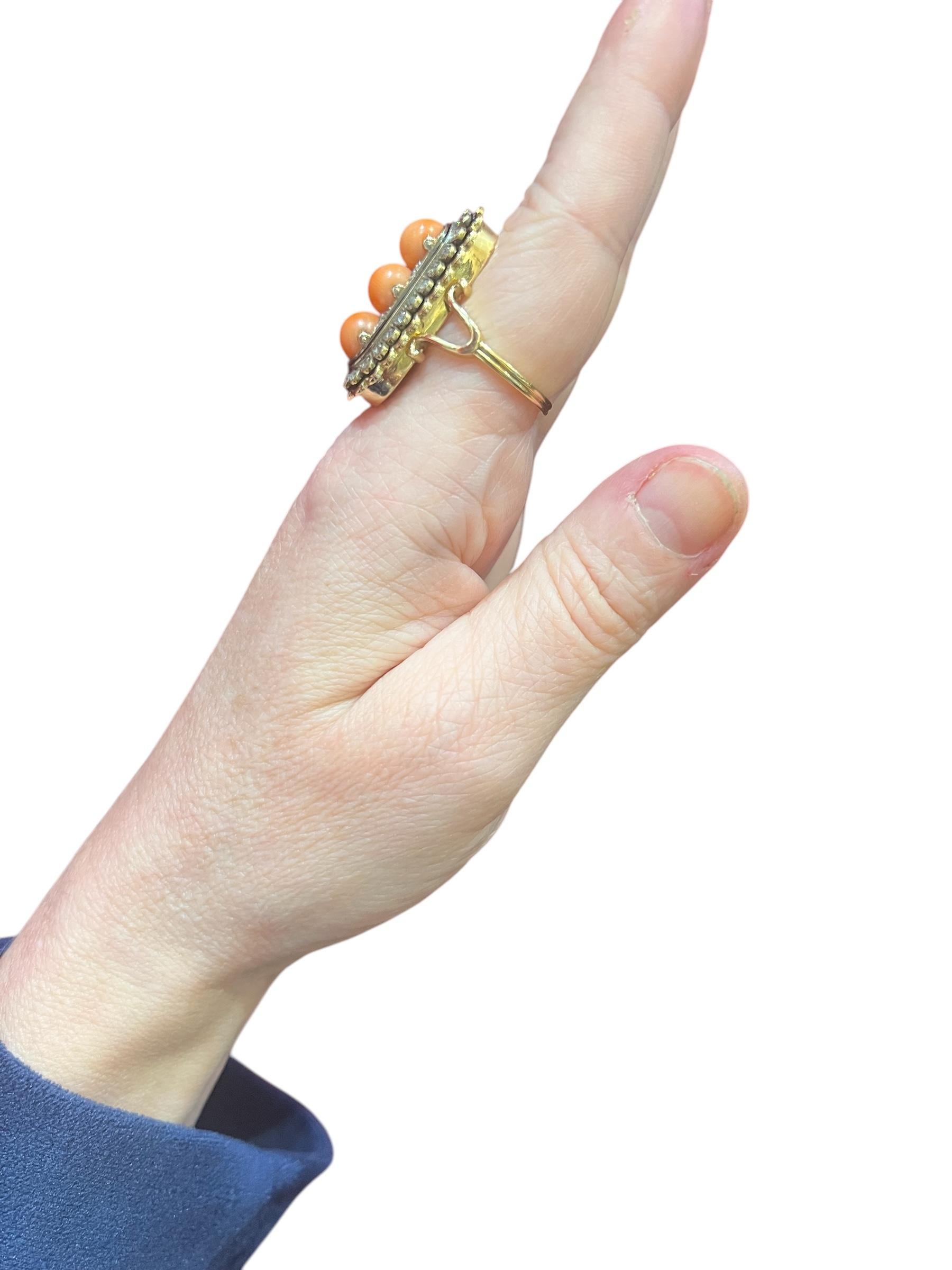 Superb clasp in 18K gold, set with 3 natural coral operles (one of which has a discreet crack visible only on the back of the ring), surrounded by a pavement of old-cut “rose” diamonds, enhanced by a black enamel filet decoration.
this clasp has