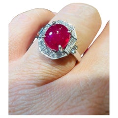 18 Carat Gold Ring Set With A Ruby Cabochon Surrounded By Diamonds