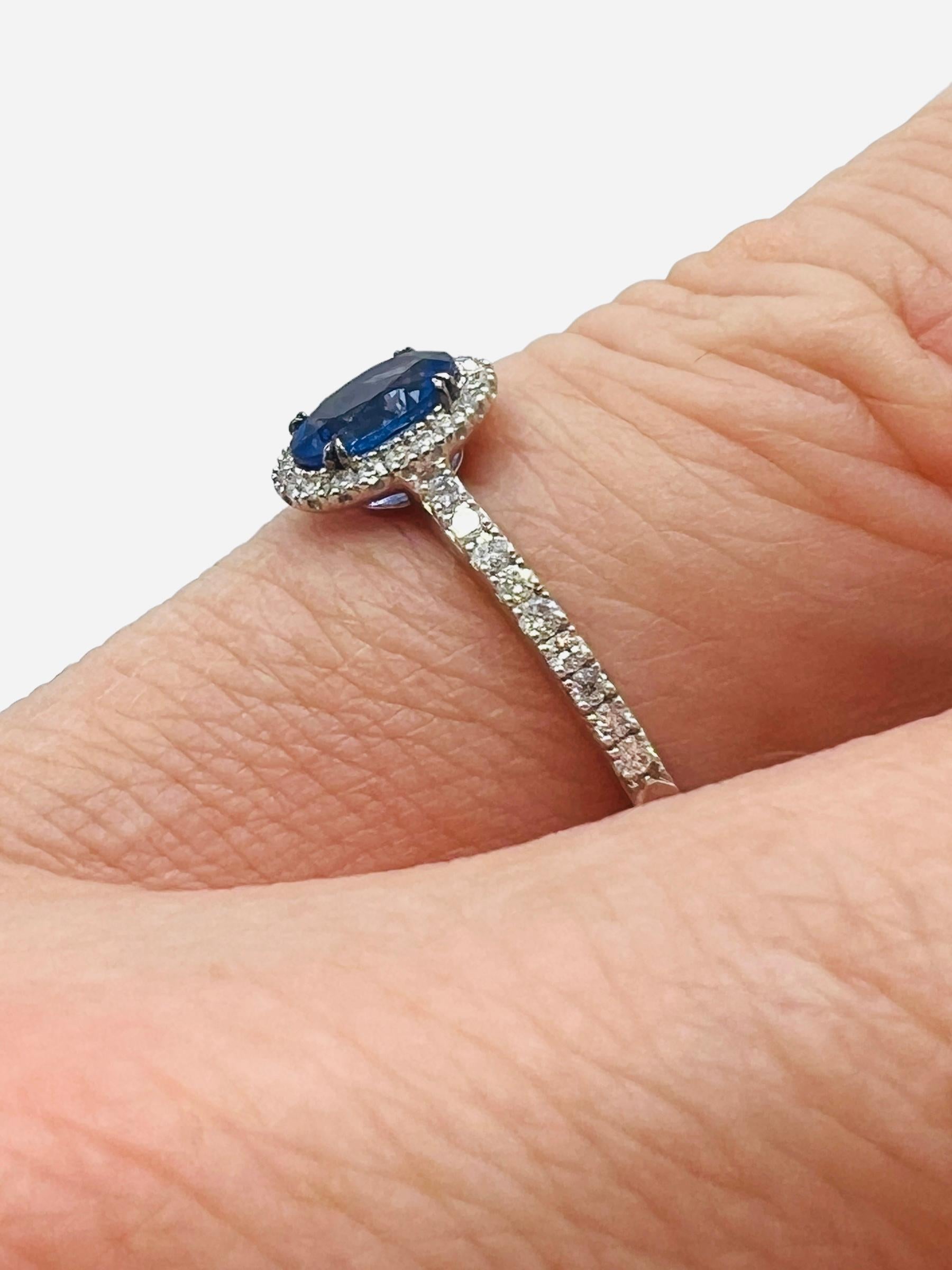 Oval Cut 18-carat gold ring set with a sapphire surrounded by brilliants