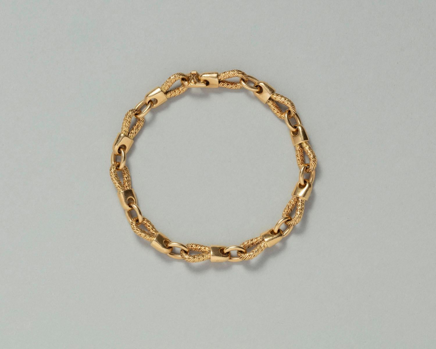 An 18 carat gold bracelet with rope and shackle links, by Georges Lenfant, Paris. 

weight: 30 grams 
length: 20 cm
