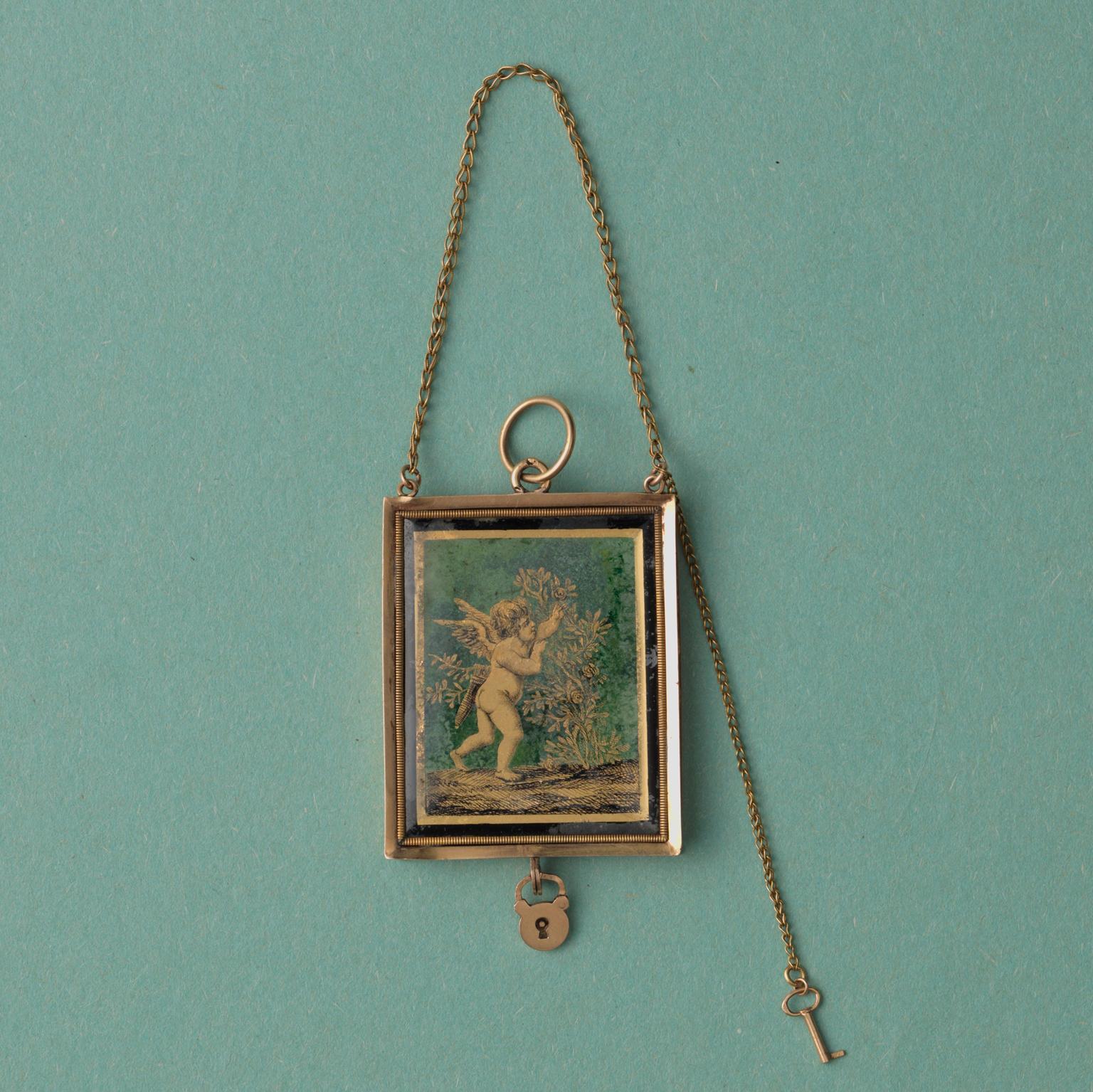 An 18 carat gold and black and gold ‘verre eglomisé’ angel locket, the little lock opens to open the locket, marked with a French gold mark for 1809-1819, wonderful condition and with all original elements. The angel is picking roses which symbolise