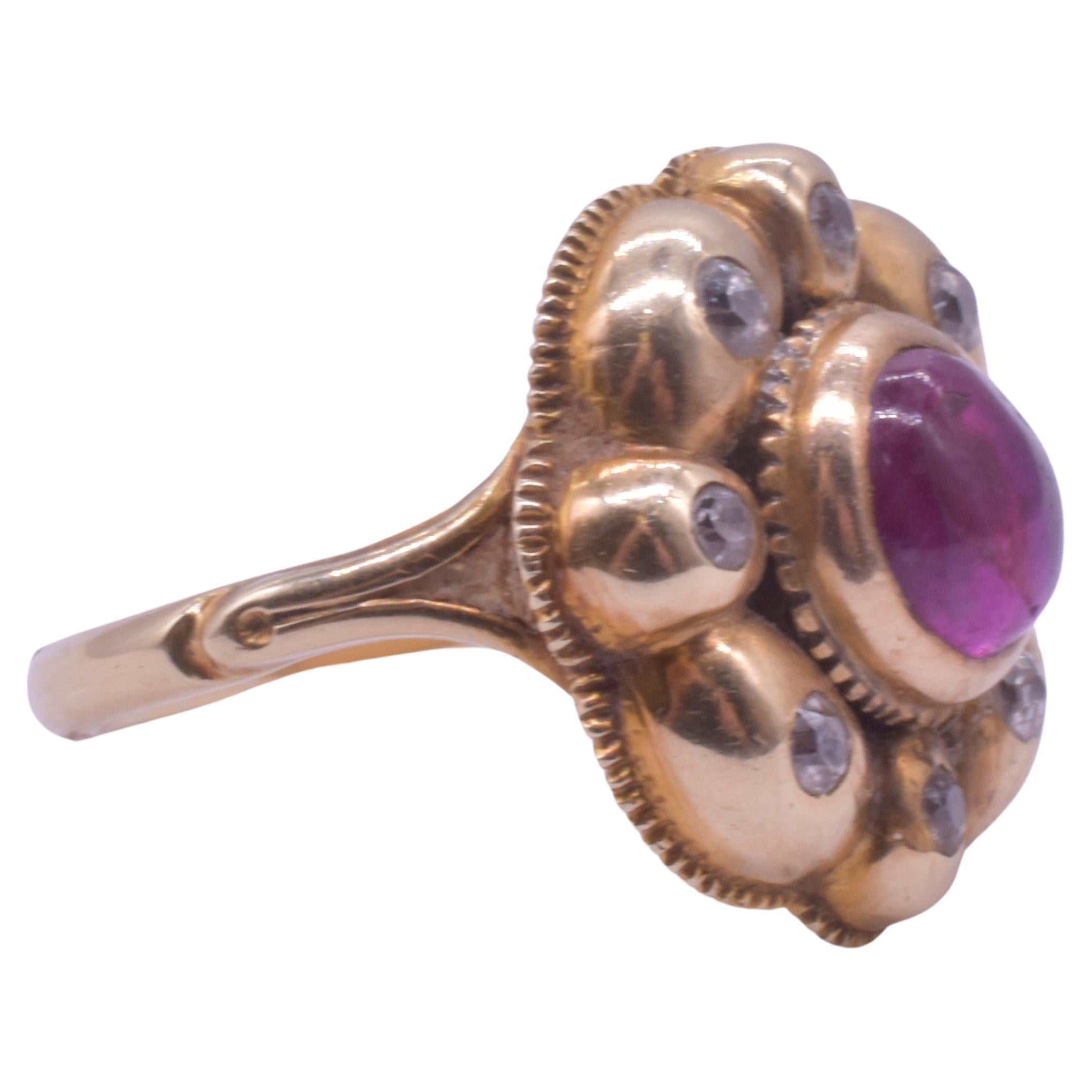 Anello a grappolo con rubino e diamanti della penisola iberica della fine del XVIII secolo, con rubino cabochon mozzafiato incastonato in una montatura d'oro a ottavo di velo con diamanti. Di origine spagnola o portoghese. 

Il bordo interno del
