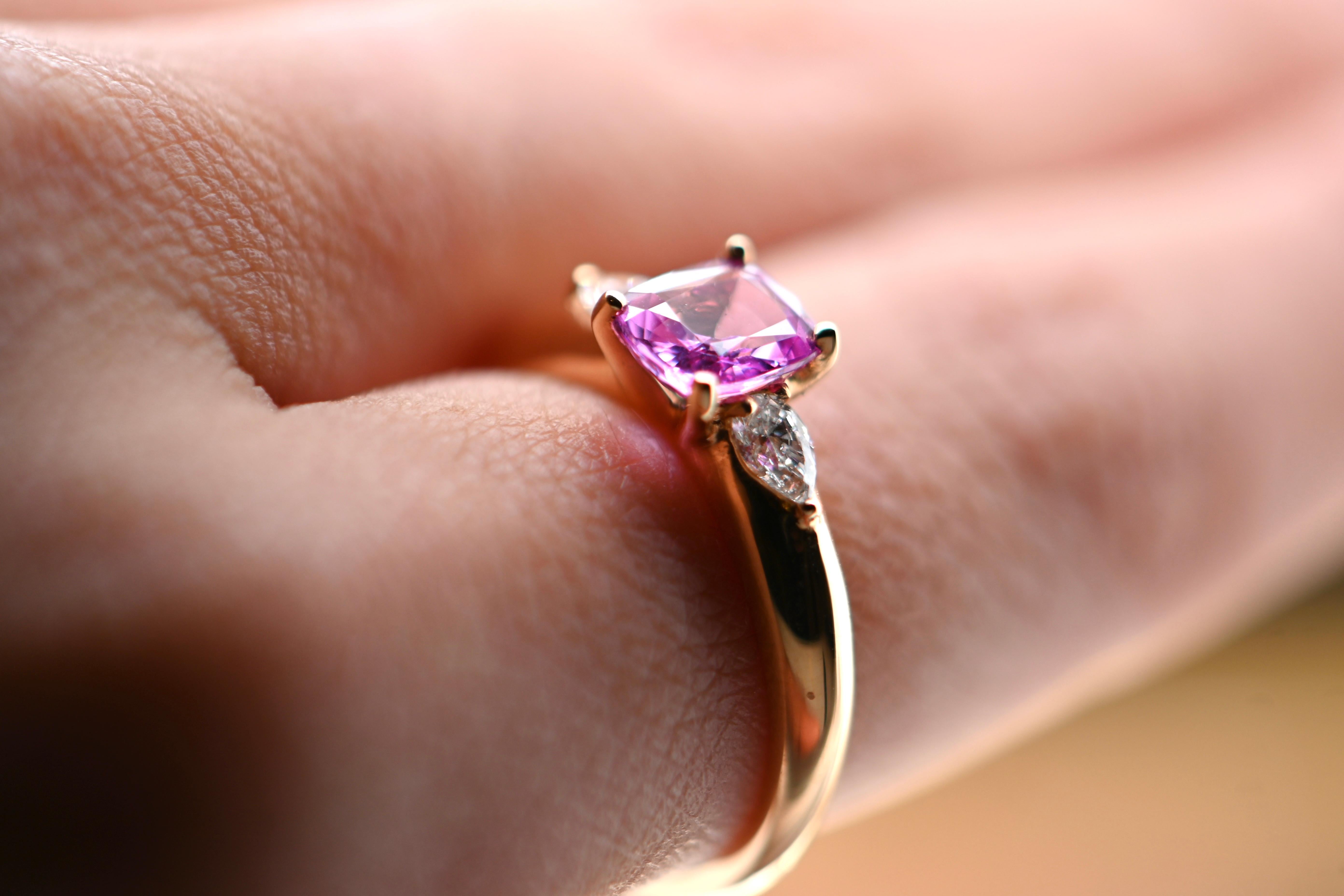 This exquisite ring, crafted from 18-carat rose gold, features a captivating pink sapphire centerpiece, elegantly framed by two sparkling diamonds. Weighing 4 grams and currently sized at 53, this piece combines lightness and comfort. Our renowned