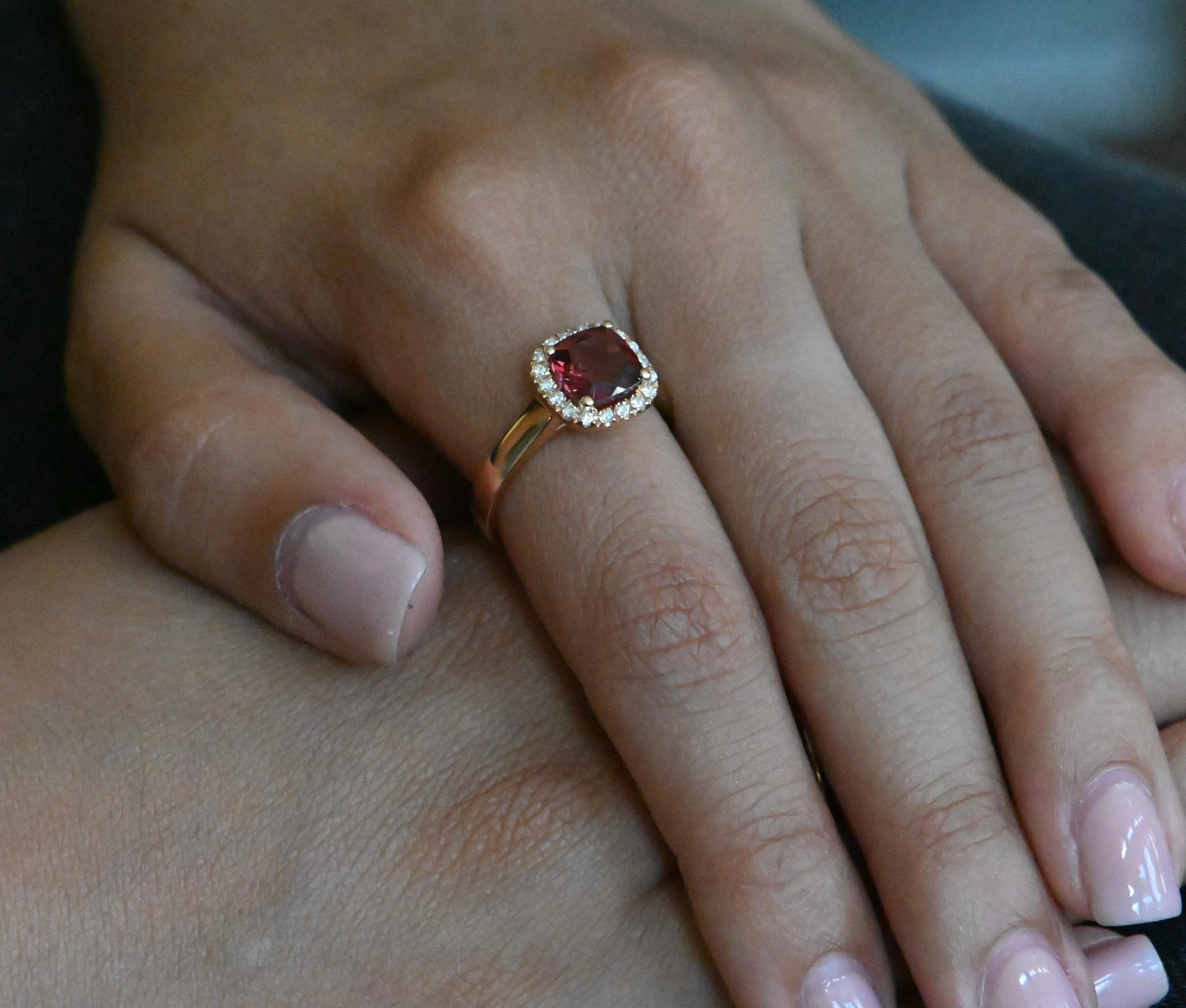 This magnificent ring in 18-carat rose gold, certified by a poinçon de maître attesting to the quality of the 750 thousandths gold, is a true masterpiece of jewelry. At the center of this creation is a 1.790-carat cushion-cut rhodolite, radiant with