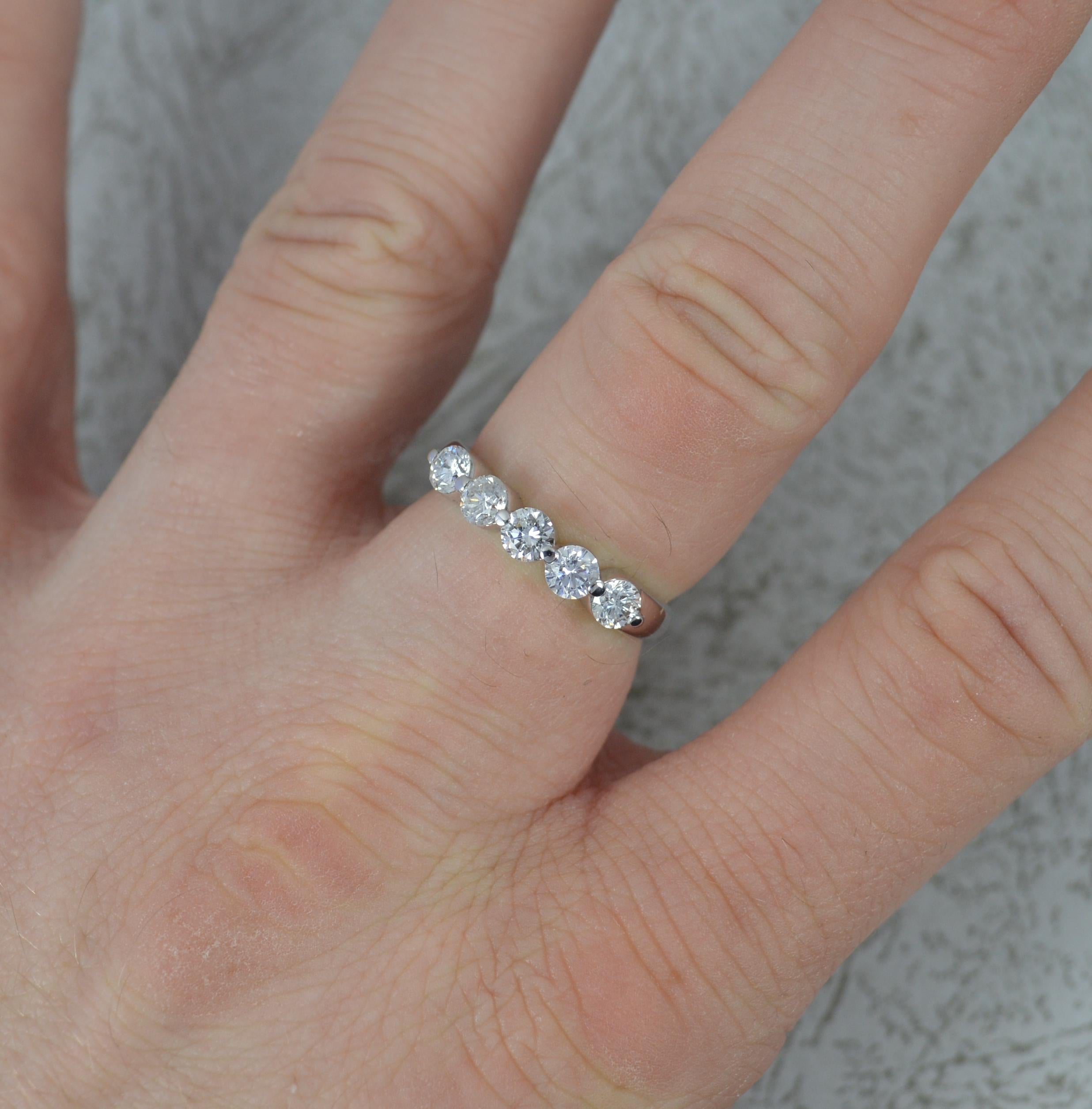 A natural Diamond and 18ct Gold ring.
​Set with five round brilliant cut diamonds, uniform size. 0.90 carat total.
All modelled in an 18 carat white gold shank with bead tension mount.
19mm spread of stones. Protruding 3.9mm off the finger.
Clean