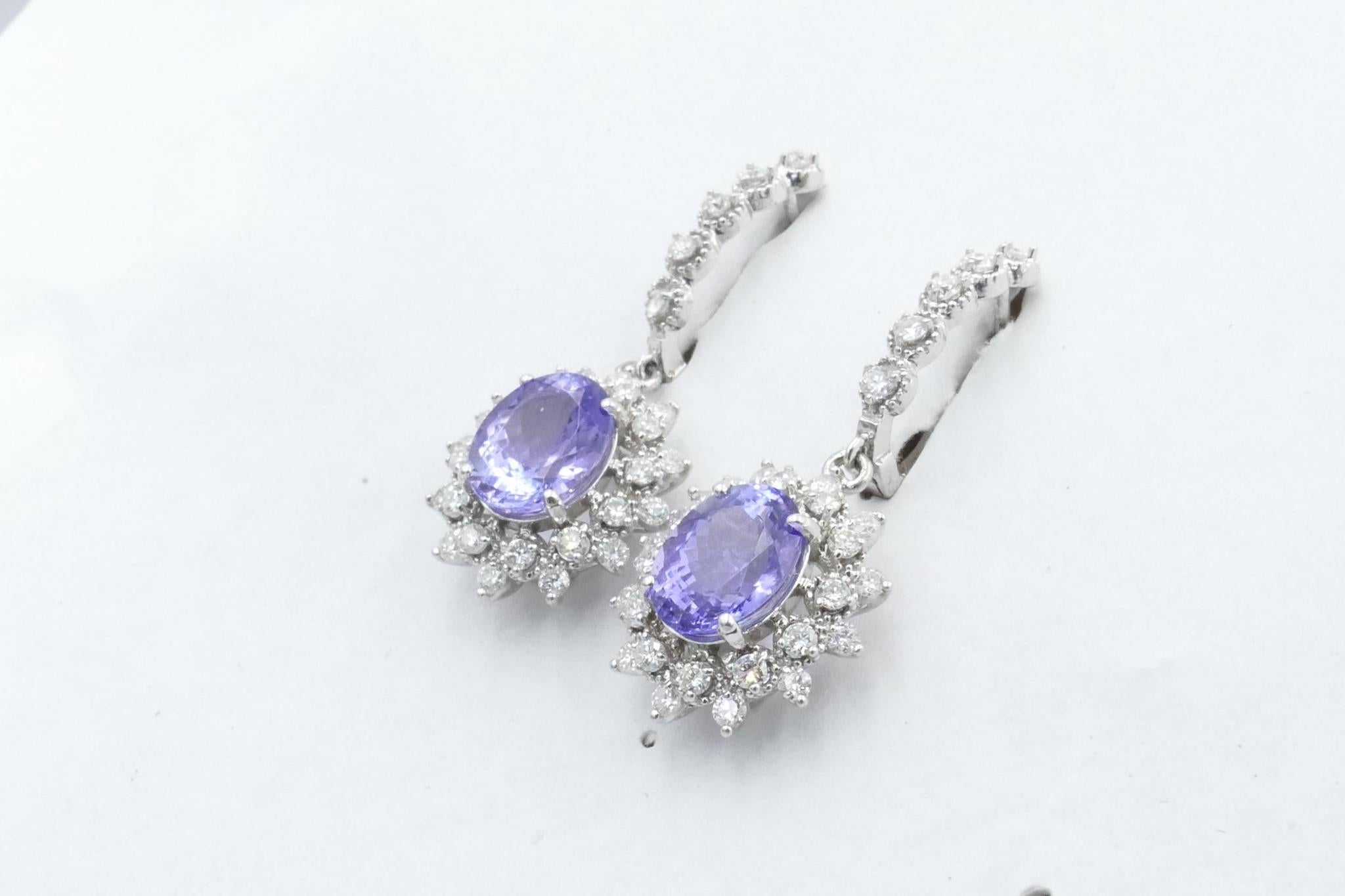 The Earrings have 2 Oval Cut tanzanites 4 Claw Set in the centre with 48 Round Brilliant Cut Diamonds totalling nearly 1 carat set along 2 rows around the centre settings.
As well 10 Round Brilliant Cut Diamonds totalling 0.2 carats, claw set, are