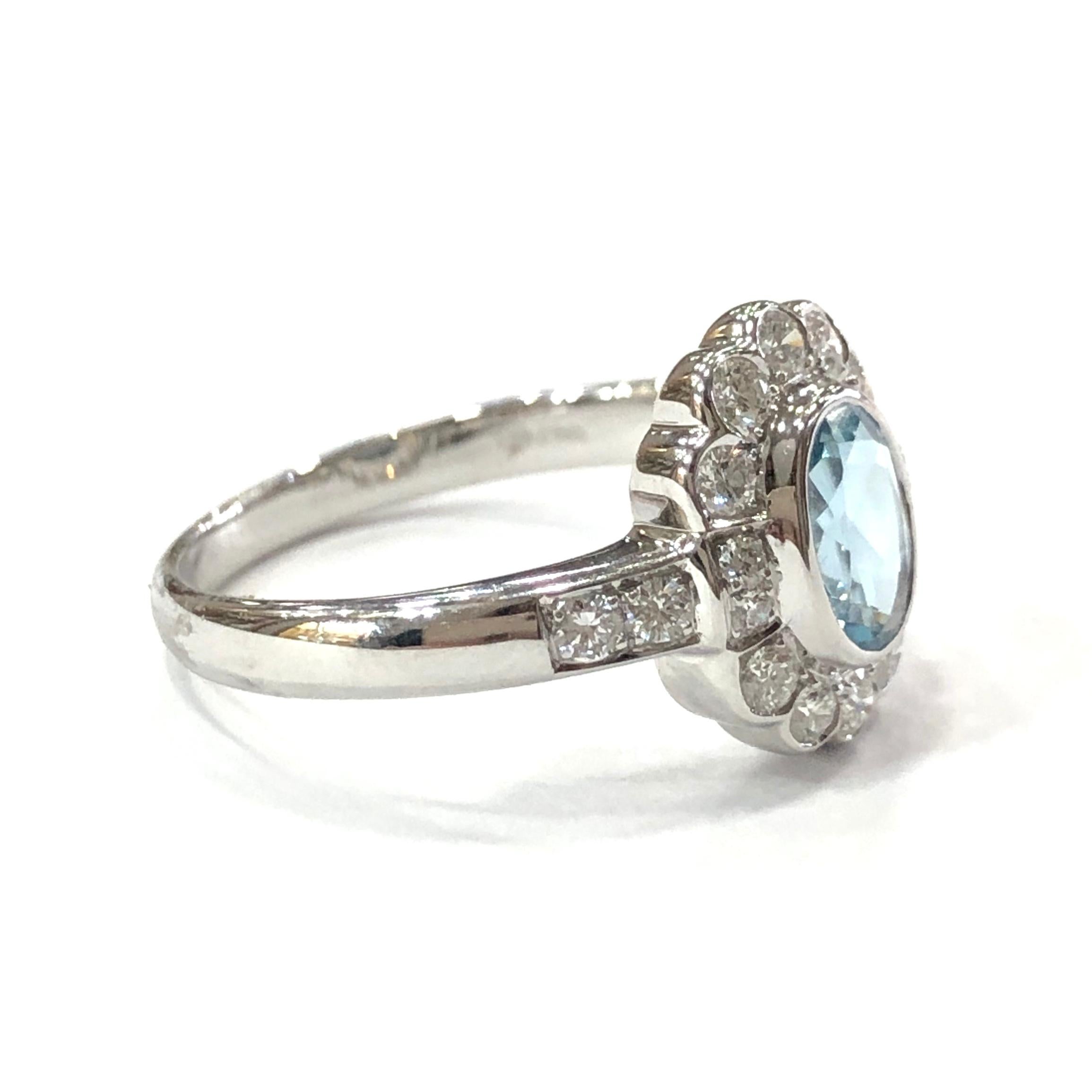 18ct White Gold Aquamarine and Diamond Cluster Ring. Set with a central oval Aquamarine set in a rubover setting. Surrounded by 14 round brilliant cut Diamonds and 4 round brilliant cut diamonds set on the shoulders.
With a full english