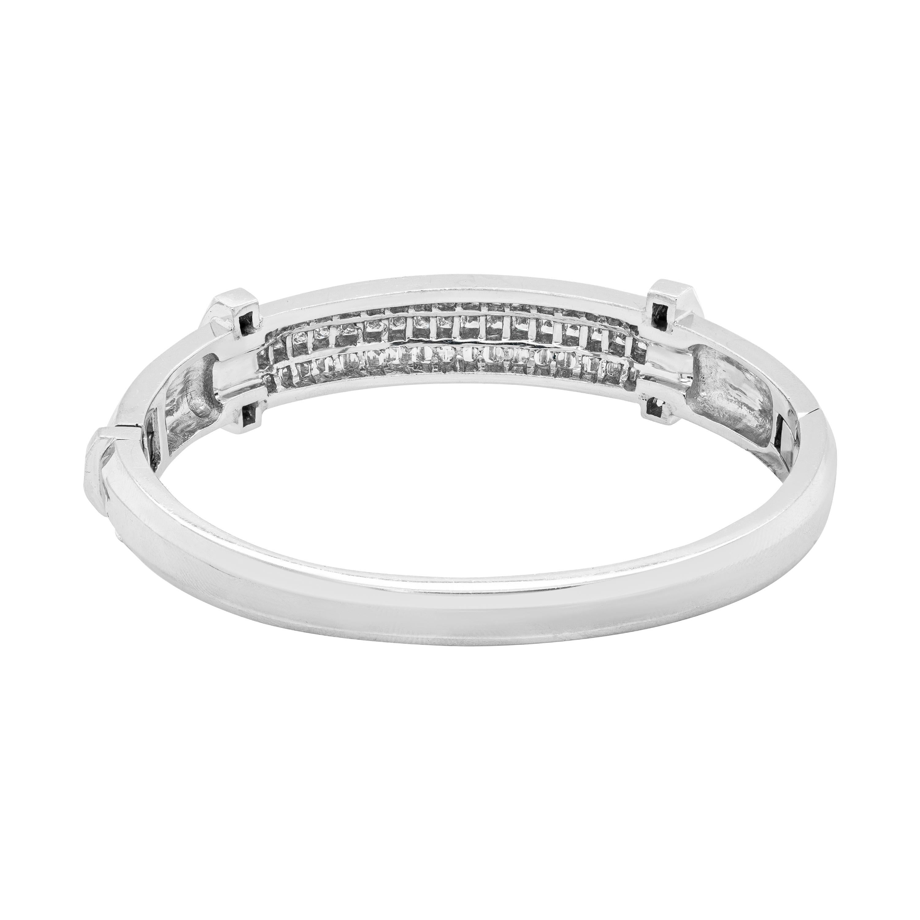 This wonderful bangle is centred with a row of 17 princes cut diamonds beautifully bordered by other two rows of 25 baguette cut diamonds each, all channel set in 18 carat white gold, open back settings. The three rows of diamonds are flanked