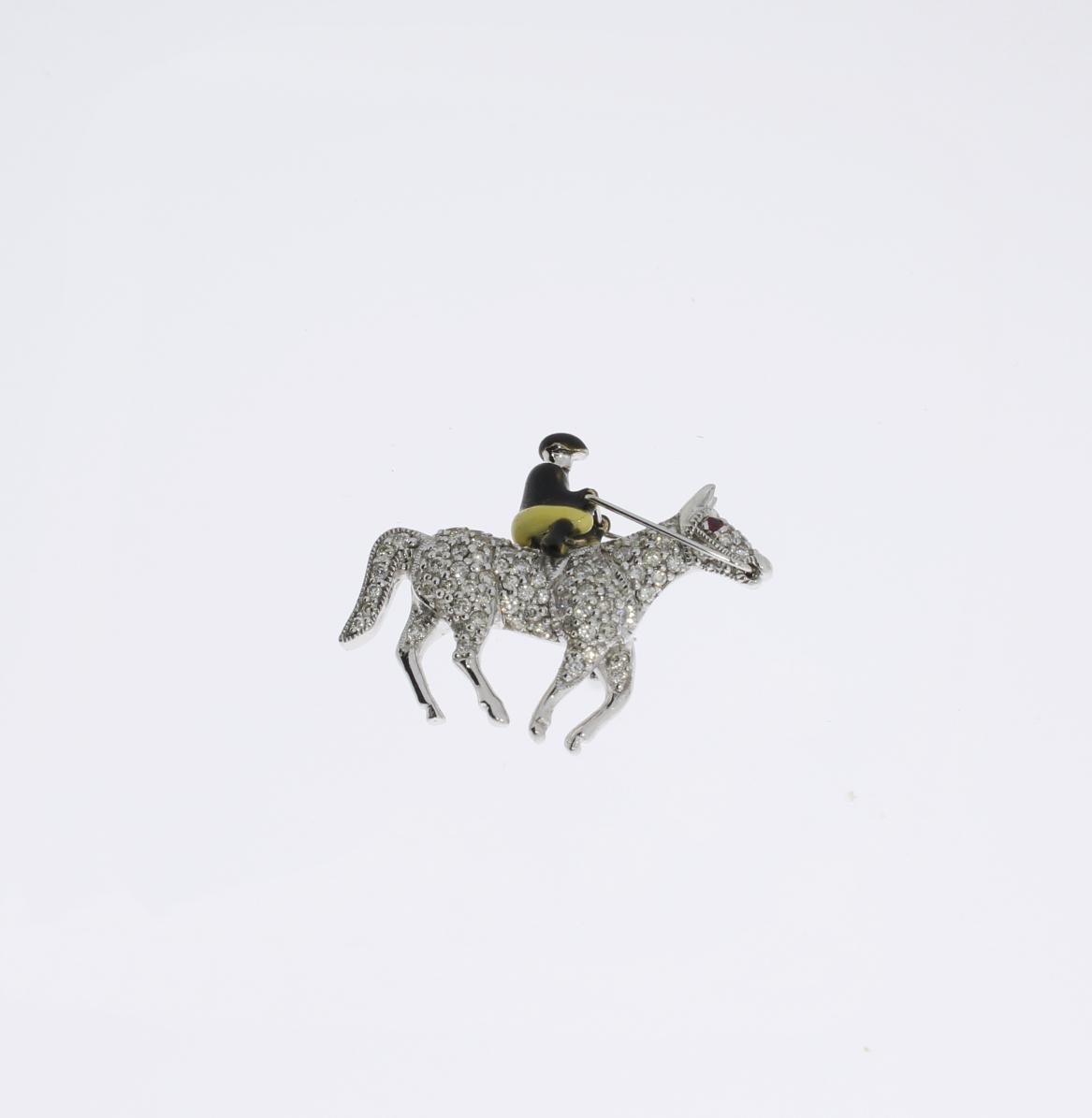 Europe, fin du 20e siècle. Le cheval est serti de 78 diamants taille brillant pesant environ 0,93 ct. et d'un rubis d'environ 0,04 ct. Le cavalier est orné d'émail. Fabriqué en or blanc 18K. Poids total : environ 11 g. 
Dimensions : 0.98 x 1.3 in (