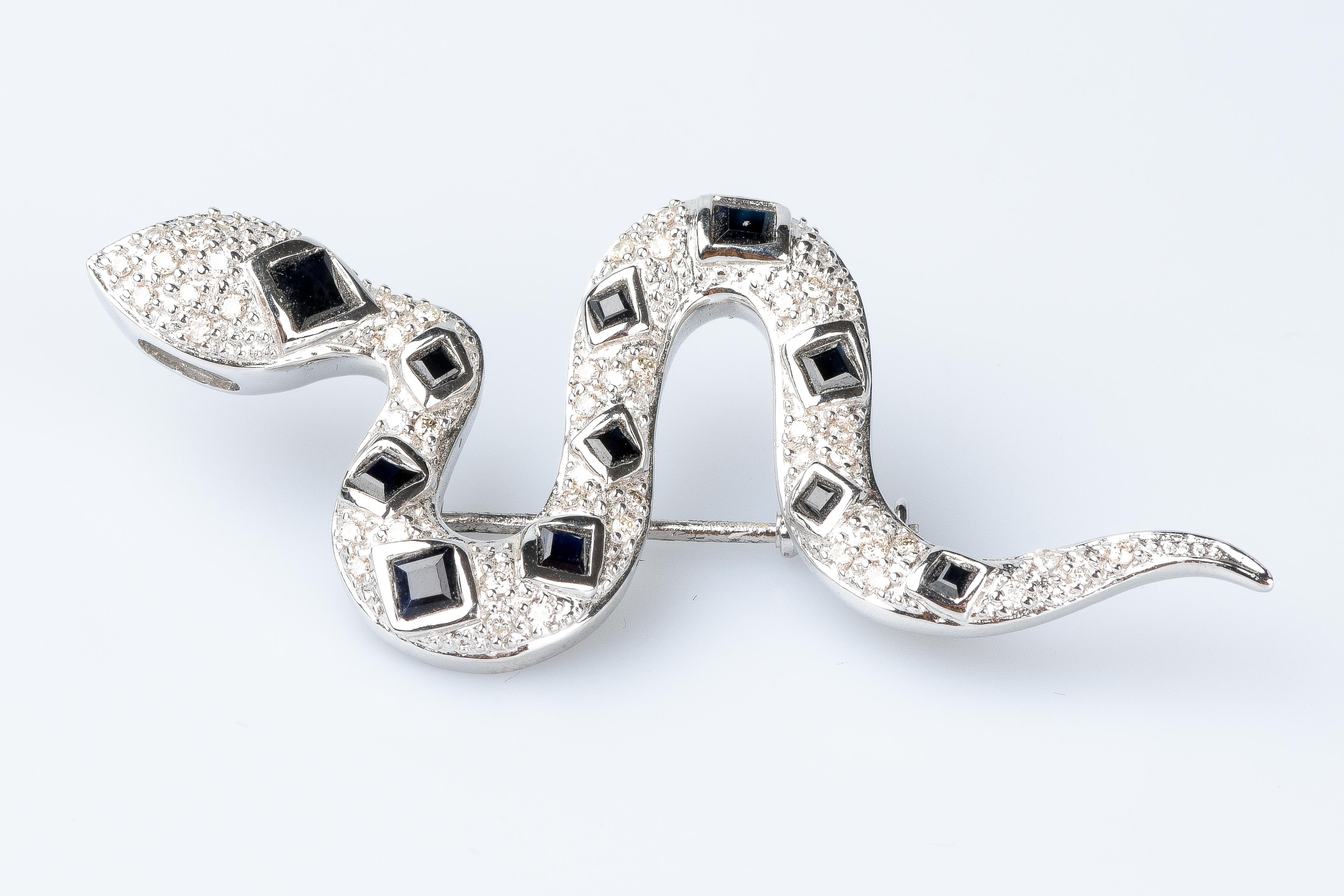 18 carat white gold snake brooch designed with 49 round brillant cut diamonds weighing 0.49 carats, 4 square cut sapphires weighing 0.44 carats 8 square cut sapphires weighing 0.24 carats.

Quality of the diamond
Color : H
Clarity : SI

 Weight :