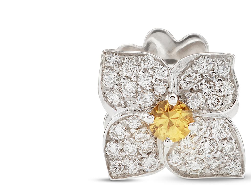 The simplicity and elegance of this white gold flower is inspired by the floral motifs of Hortense.
The flowers placed on the earrings is decorated with white diamonds and embellished with yellow sapphire gemstones that give shine to the
