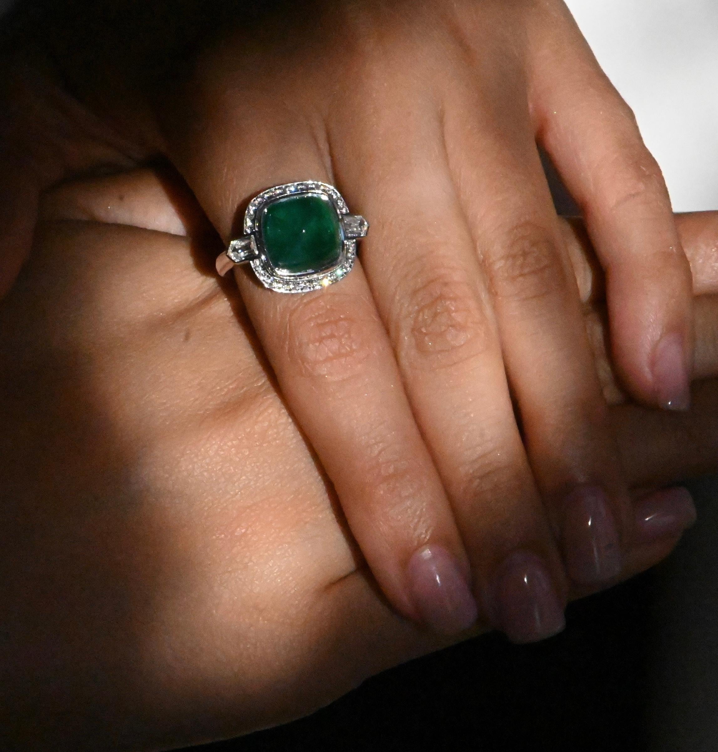 Dieser atemberaubende Ring ist mit einem prächtigen 6,720-karätigen Smaragd verziert, der in Form einer Zuckerkiefer geschliffen ist und das Licht mit außergewöhnlicher Brillanz einfängt. Eingerahmt von zwei Diamanten von je 0,440 Karat sowie 24