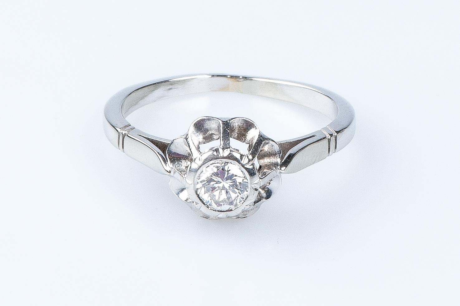 18 carat white gold flower ring designed with 1 round brillant cut diamond weighing 0.29 carat. 

Quality of the diamond
Color: H
Clarity: SI

Weight:  3.30 gr. 

Size: EU: 55 - SP/IT: 15 - US: 7.5

Dimensions : 0.90 x 0.90 x 0.15 cm 

Jewel