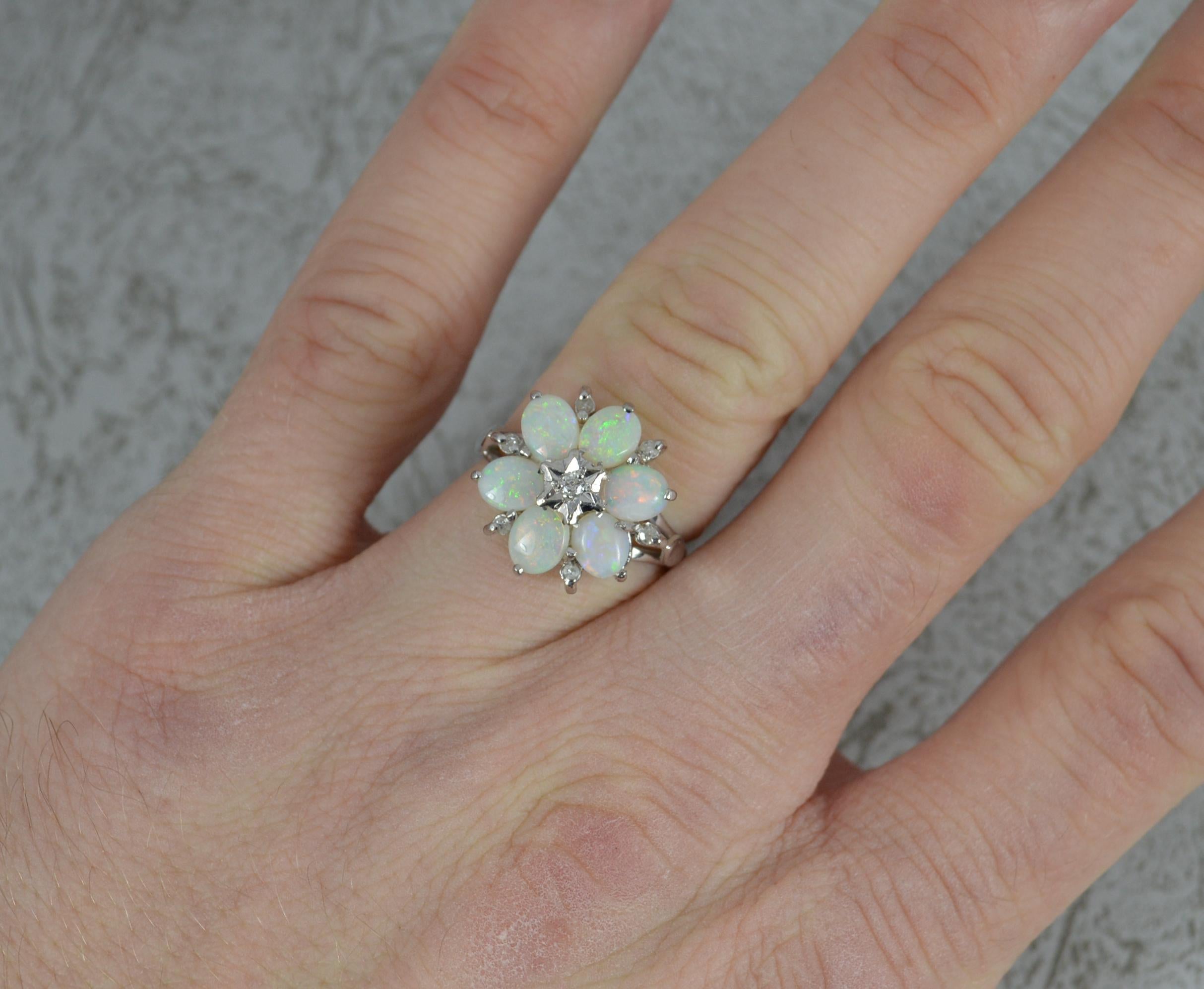 A superb vintage cluster ring.
Solid 18 carat white gold example.
Designed as a cluster comprising of six oval shaped natural opals with a diamond in illusion setting to centre and six further diamonds to the edge.
15mm x 16mm cluster head.