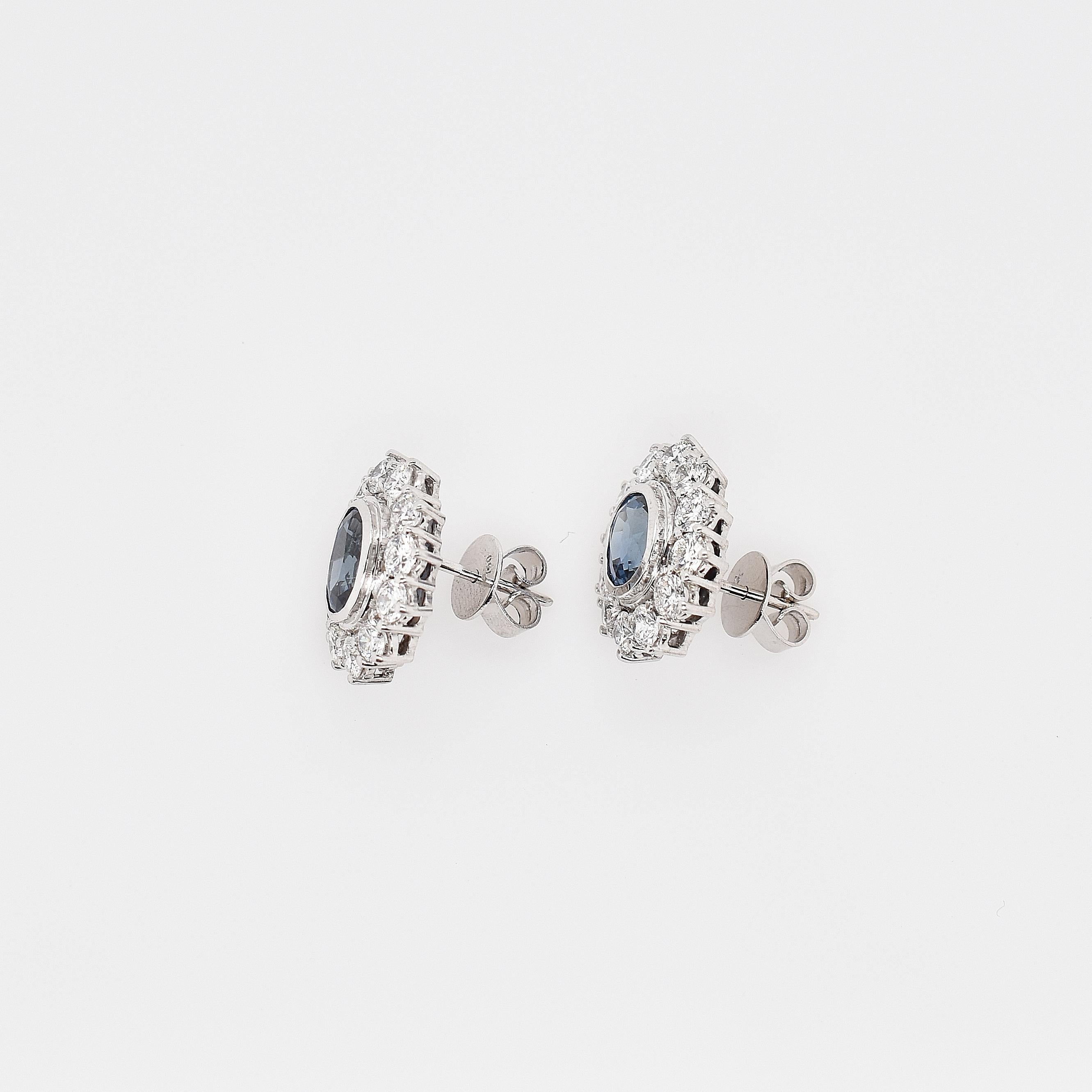 18ct white gold Ceylon oval sapphire and diamond cluster stud earrings. Two oval cut sapphires totalling 3.89ct. 24 surrounding round brilliant cut diamonds totalling 2.67ct H SI1

