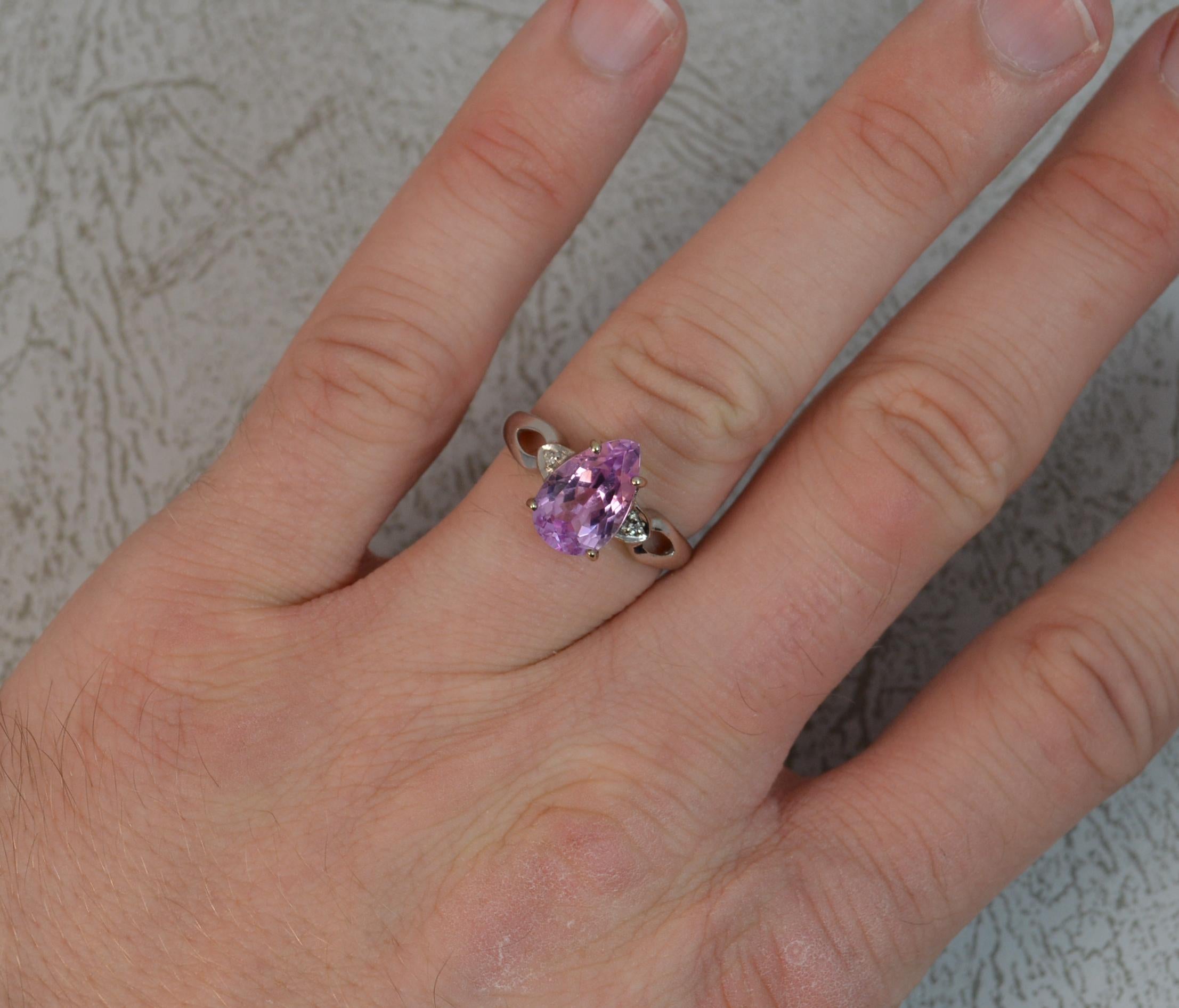 A superb contemporary ring.
Solid 18 carat white gold shank.
Designed with a pear cut pink kunzite to the centre in four claws.
Attractive pink coloured stone with a diamond to each side.
7.1mm x 11.1mm stone. Protruding 6.5mm off the