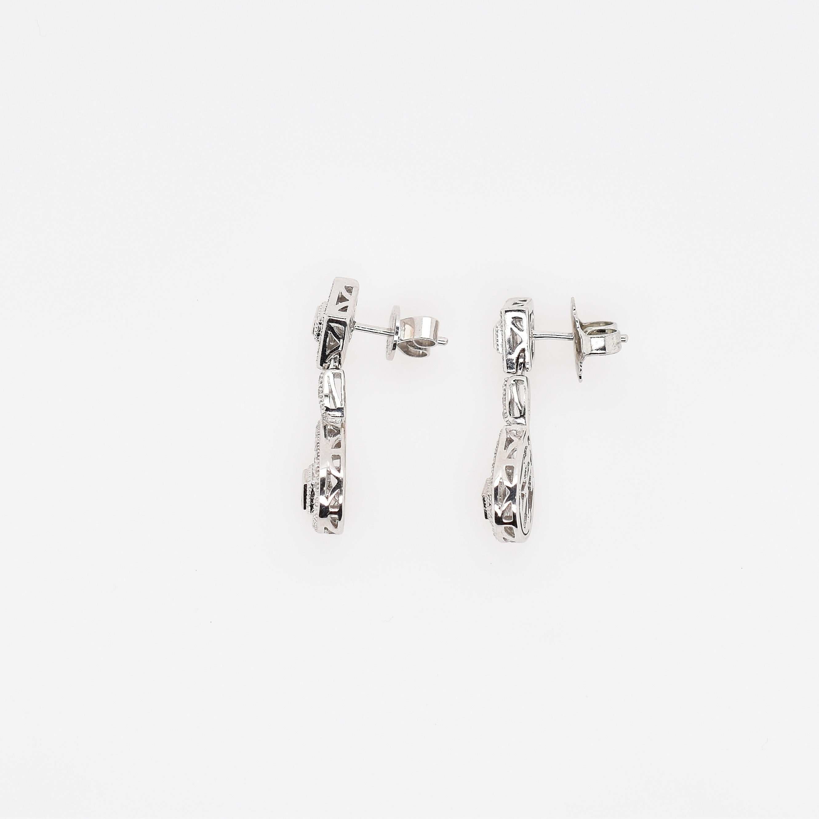 18ct White Gold Diamond Cluster Drop Earrings with total diamond weight 1.00ct IJ SI2.
There are 4 princess cut diamonds as centre feature in each cluster, surrounded by briliant cut diamonds in a mille grained setting.
They are post and butterfly  