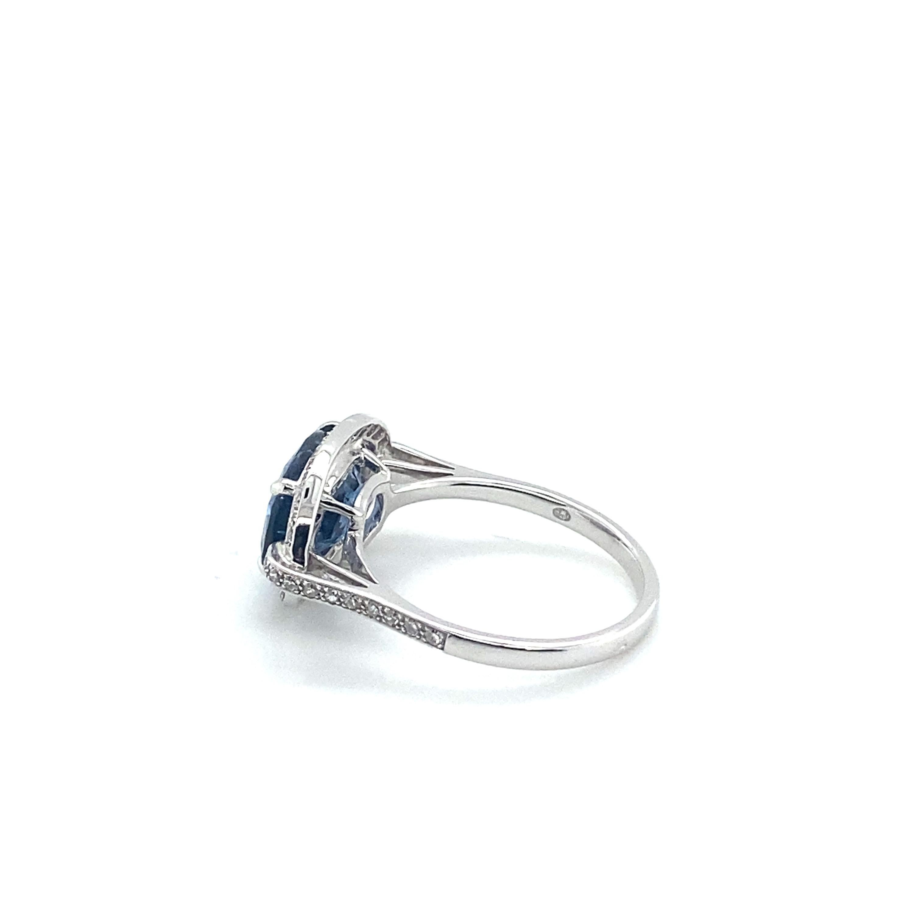 Modern 18 Carat White Gold Ring Topped with a Blue Spinel Surrounded by Diamonds For Sale
