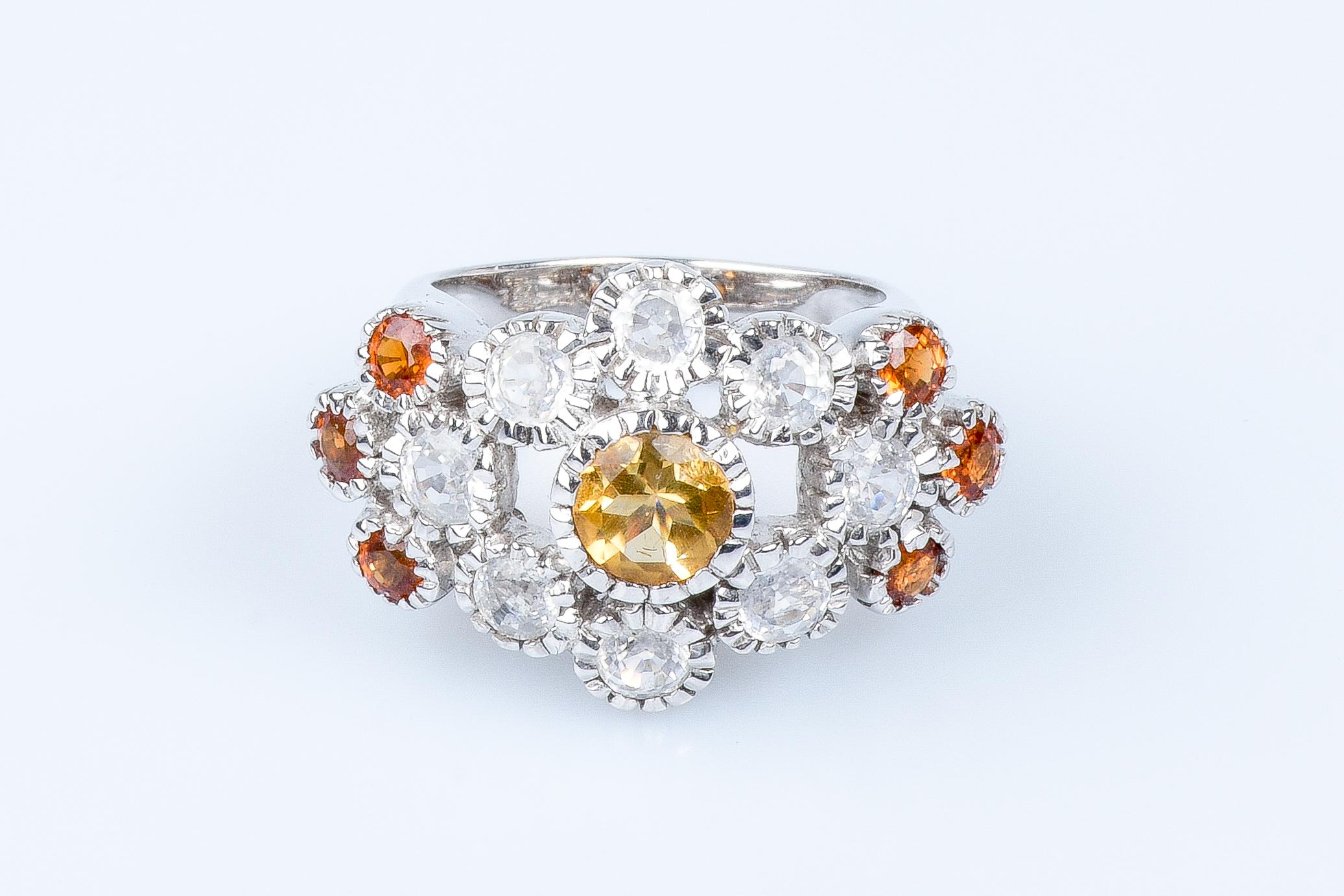 18 carat white gold ring designed with 1 round citrine weighing 0.72 carats, with 8 round white sapphires weighing 2.24 carats and 6 round topazes weighing 1.13 carats.

Quality of the diamond:
Color : H
Clarity : SI

 Weight : 15.49 gr. 

Size: EU