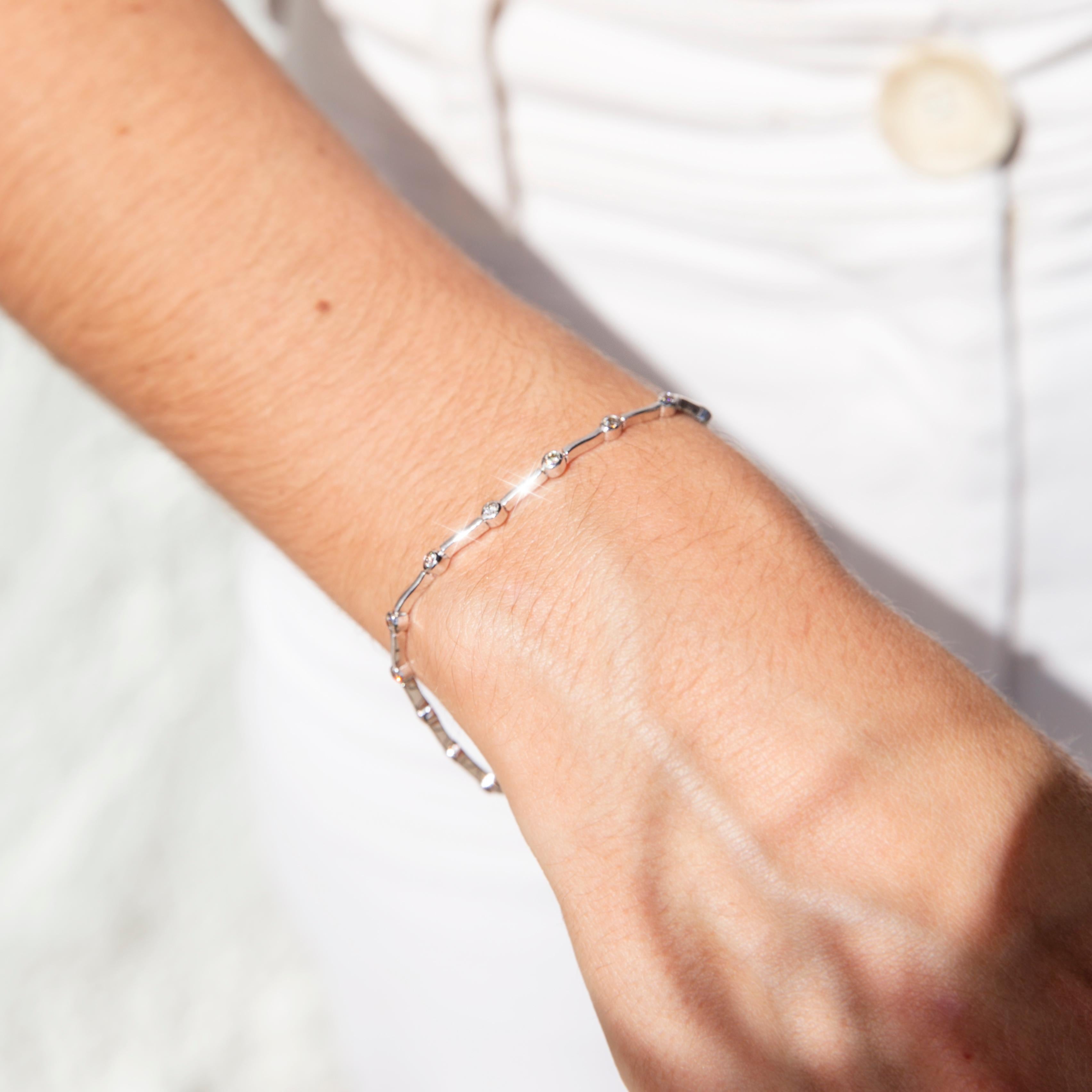 Crafted in 18 carat white gold, this darling vintage tennis bracelet features seventeen shimmering round brilliant cut diamonds in elegant rub over settings, linked with curved white gold bars. We have named her The Kian Bracelet. A wonderful
