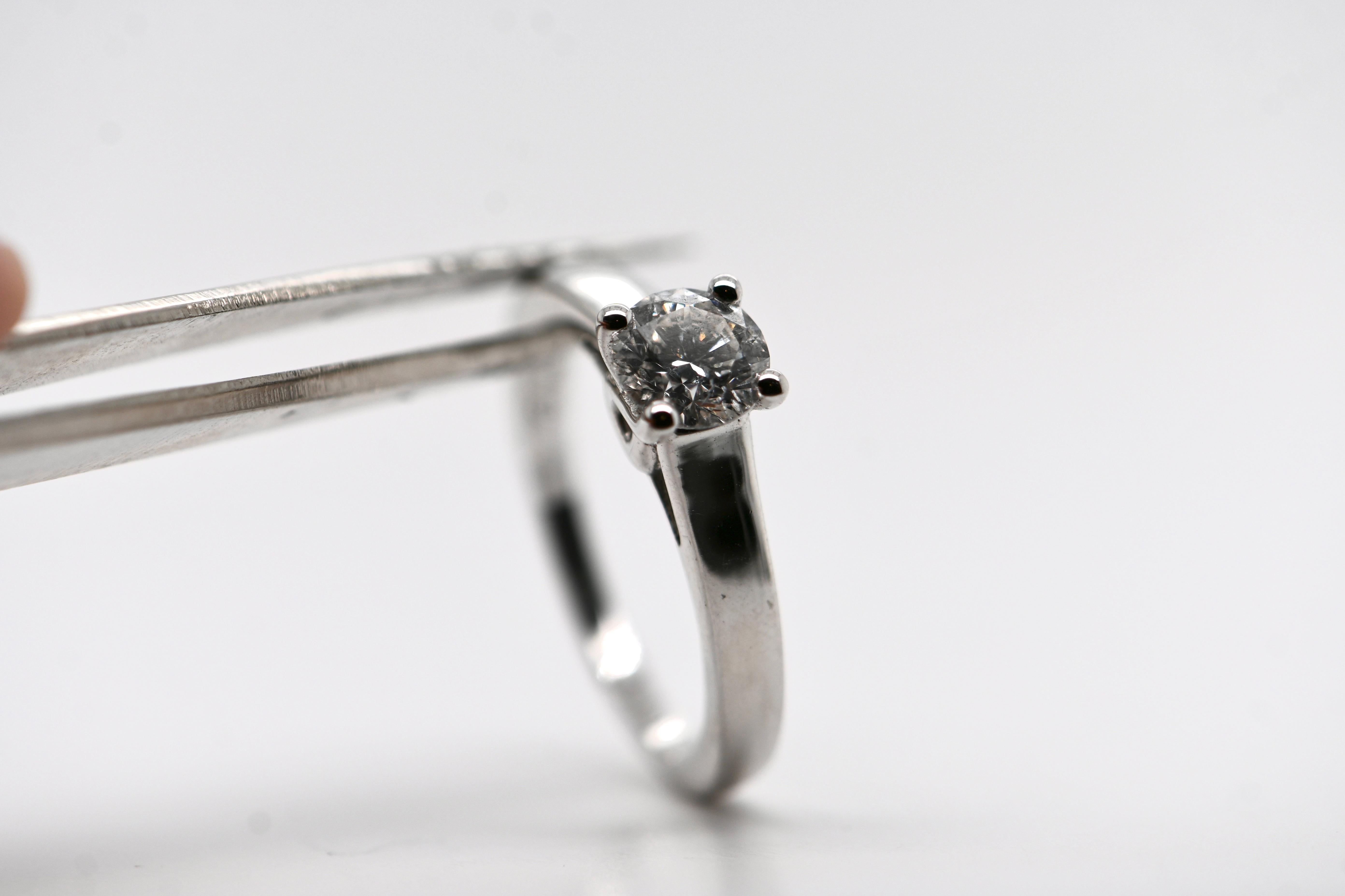 Indulge in the timeless elegance of this 18-carat white gold solitaire ring, featuring a brilliant-cut diamond weighing 0.750 carats and boasting an exquisite H color grade. The ring's all-white gold structure is meticulously crafted to allow light