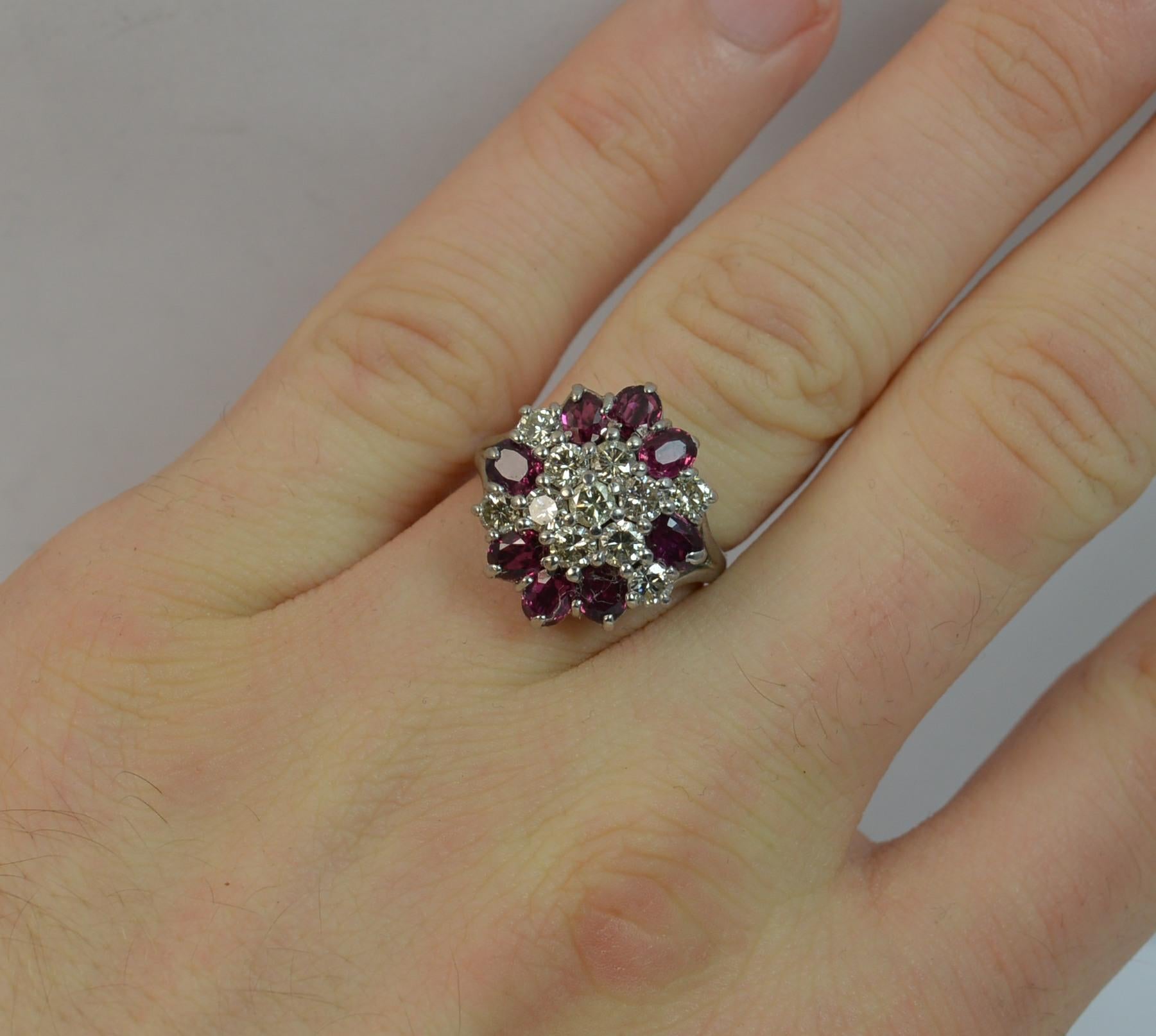 
A stunning vintage Ruby and Diamond ring.

Designed with seven round brilliant cut diamonds to the centre forming a daisy head with a surround of eight oval cut rubies and four round cut diamonds.

Total carat weight of approx 0.90 carats, VS