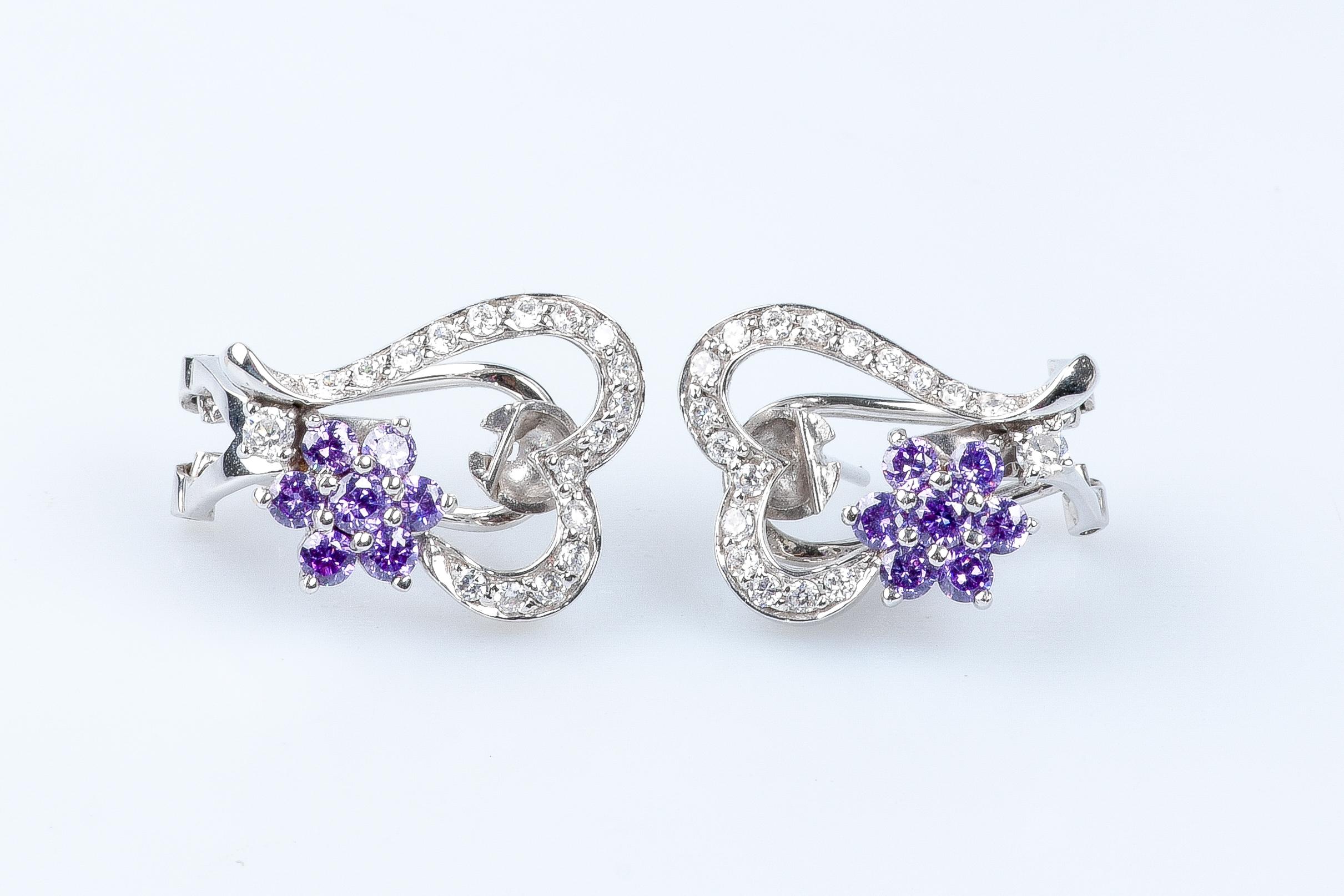 18 carat white gold earrings designed with 7 mauve zirconium oxides and 18 zirconium oxides.

Weight:  10.20 gr.

Dimensions : 2.00 x 1.60 x 0.40 cm 

Jewel delivered in a luxurious box with a certificate of authenticity Monte-Carlo Bijoux.