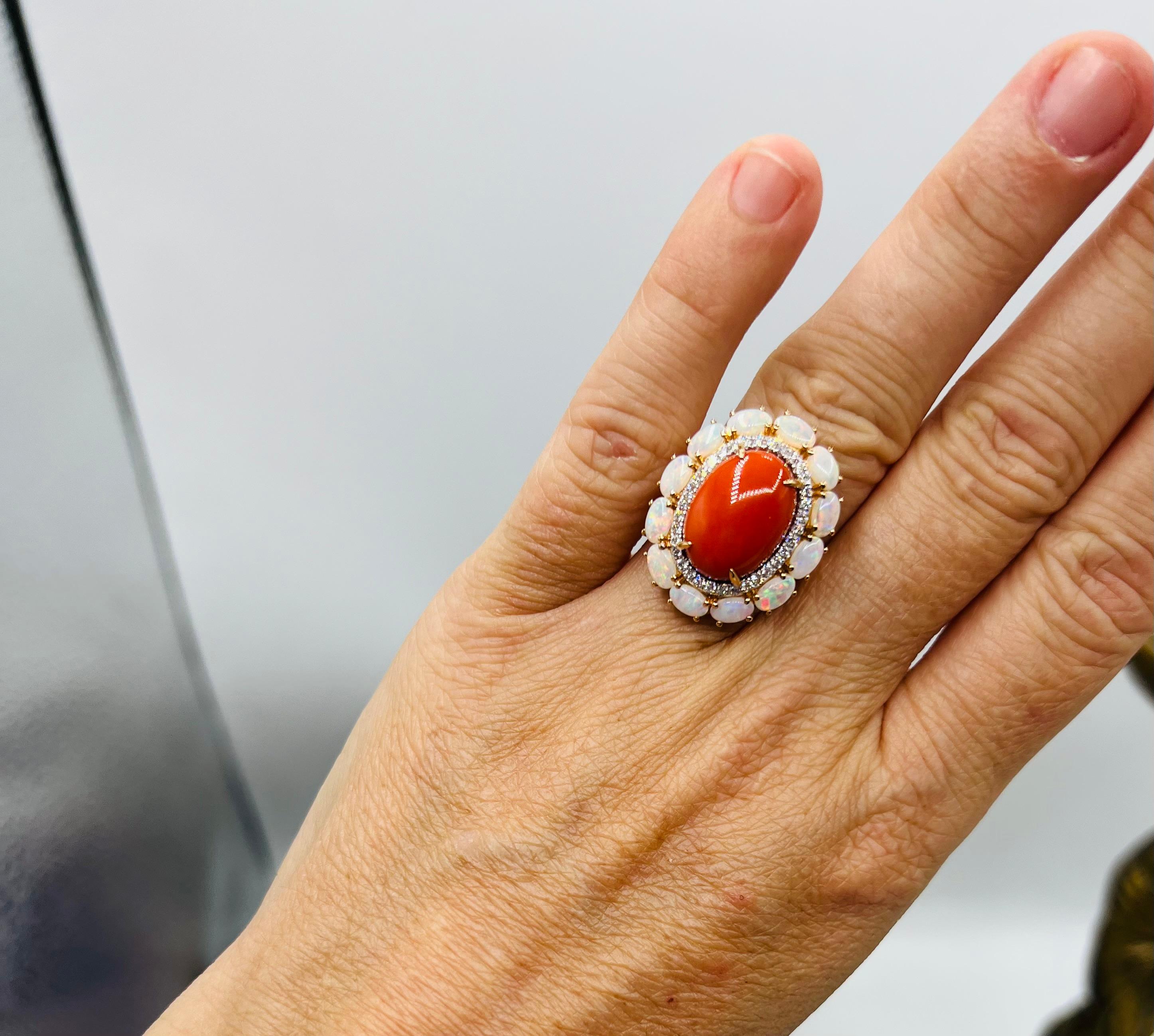 Superb 18-carat yellow gold ring set in its center a magnificent oval coral cabochon of beautiful uniform orange red color

Surrounded by brilliants in paving for about 0.30 carat in full,

Also surrounded by oval cabochon opals

Total weight: 8.98