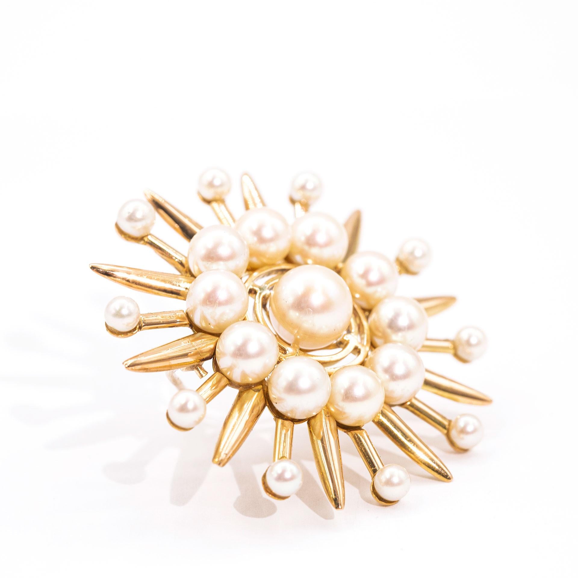 Forged in 18 carat yellow gold is this charming vintage brooch, Circa 1900s, which features a cluster of 11 slightly off round cultured pearls and is further surrounded by a border of 10 smaller freshwater white pearls.   Both the cultured and