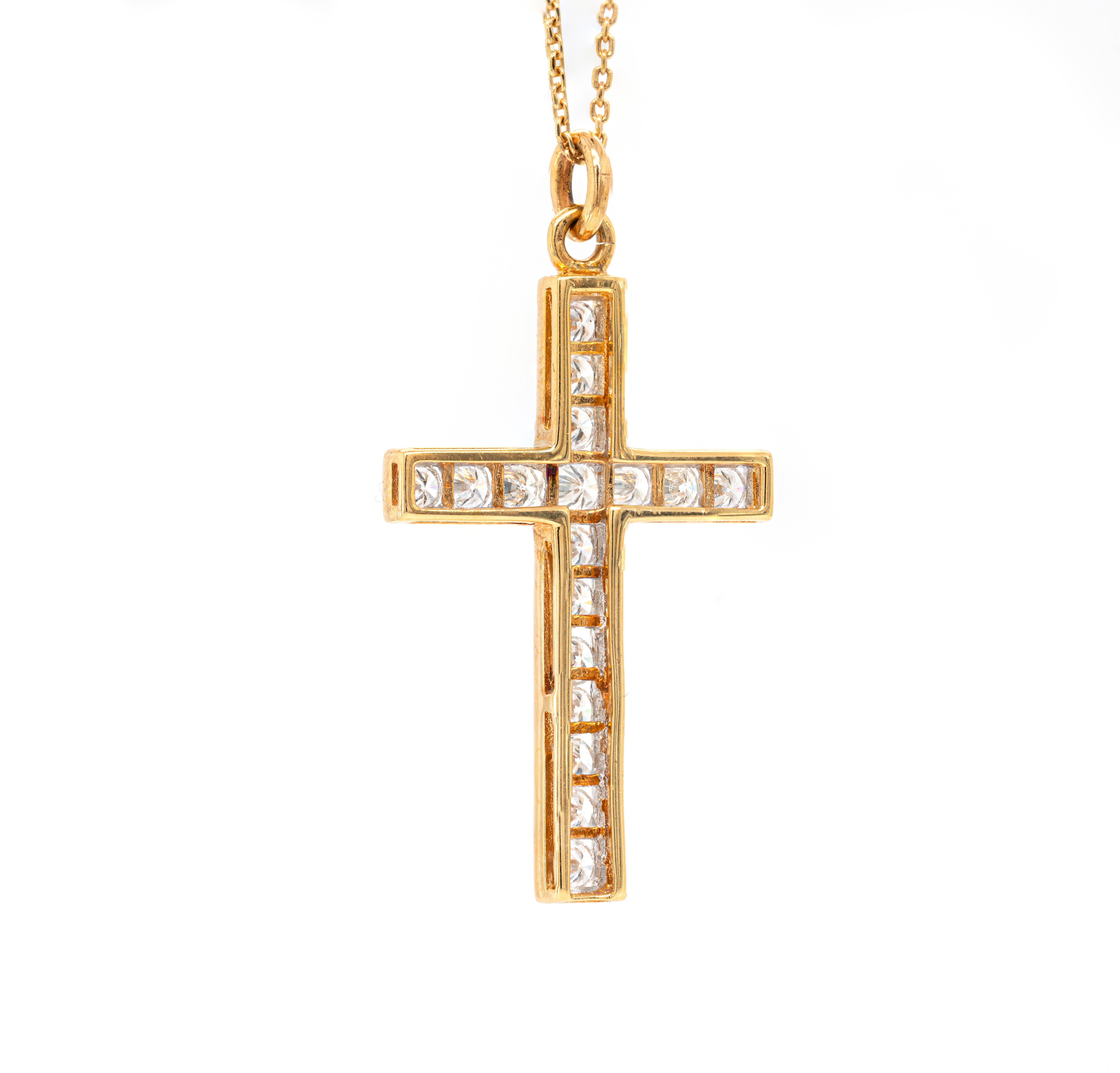 Ce magnifique pendentif en forme de croix classique présente 17 diamants ronds de taille brillant d'un poids total approximatif de 1,50 carat, tous sertis en canal dans une monture en or jaune 18 carats. Ce magnifique pendentif mesure 4,0 x 2,2 cm