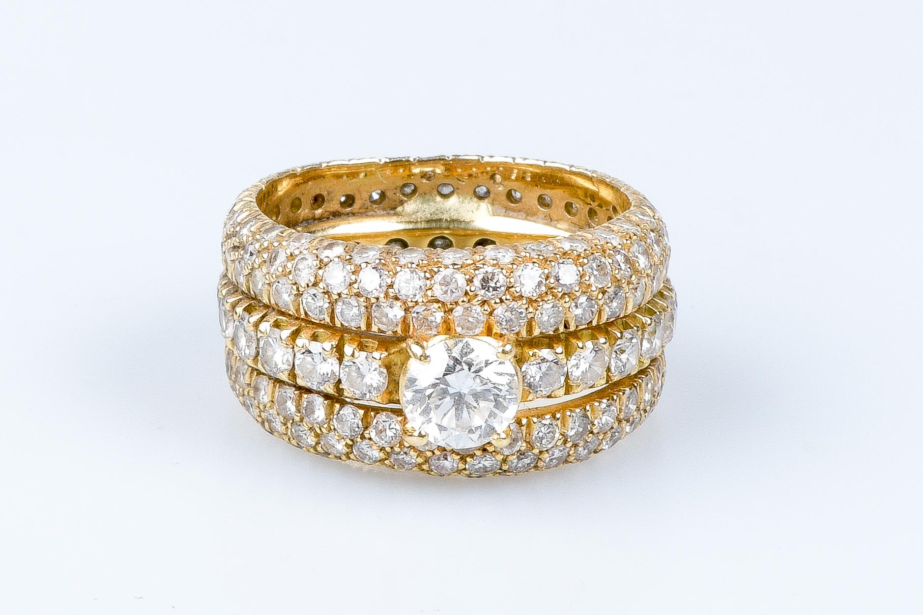 18 carat yellow gold ring designed with 1 central round brillant cut diamond weighing 0.73 carats, surrounded by 20 round brillant cut diamonds weighing 1.24 carats, by 2 round brillant cut diamonds weighing 0.084 carats, by 1 round brillant cut