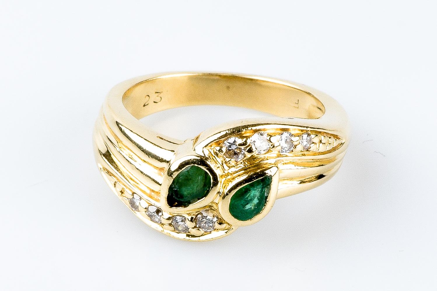 18 carat yellow gold emeralds diamonds ring designed with 2 emeralds weighing 0.16 carat and 8 round brilliant cut diamonds, 2 diamonds weighing 0.048 carat, 4 diamonds weighing 0.048 carat and 2 diamonds weighing 0.02 carat.                   