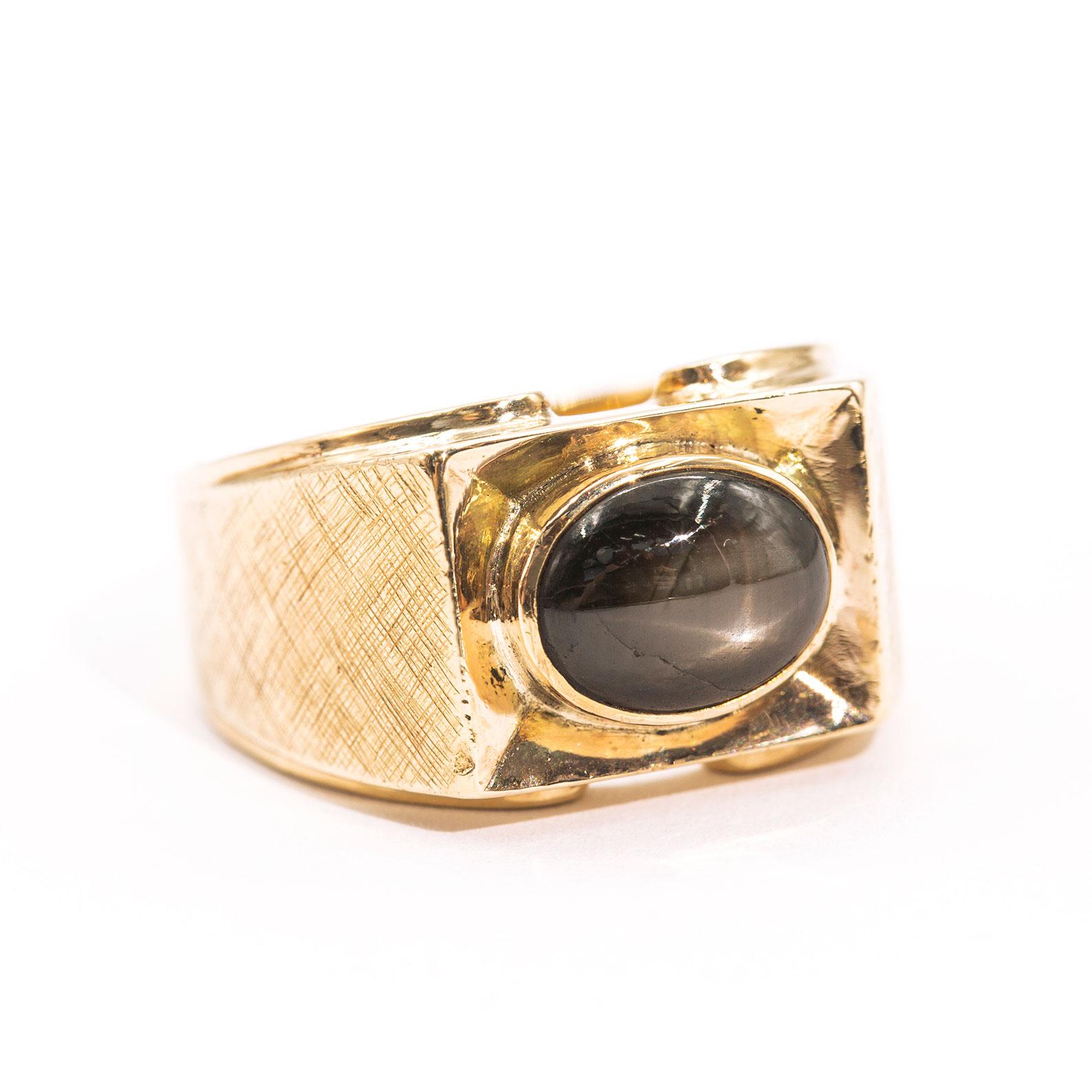 Carefully crafted in 18 carat yellow gold, this handsome vintage signet ring features a 9x7 millimetre 6 ray star natural brown sapphire. We have named this dapper ring The Thomas Ring. With fine textured detailing on the band and the rectangular