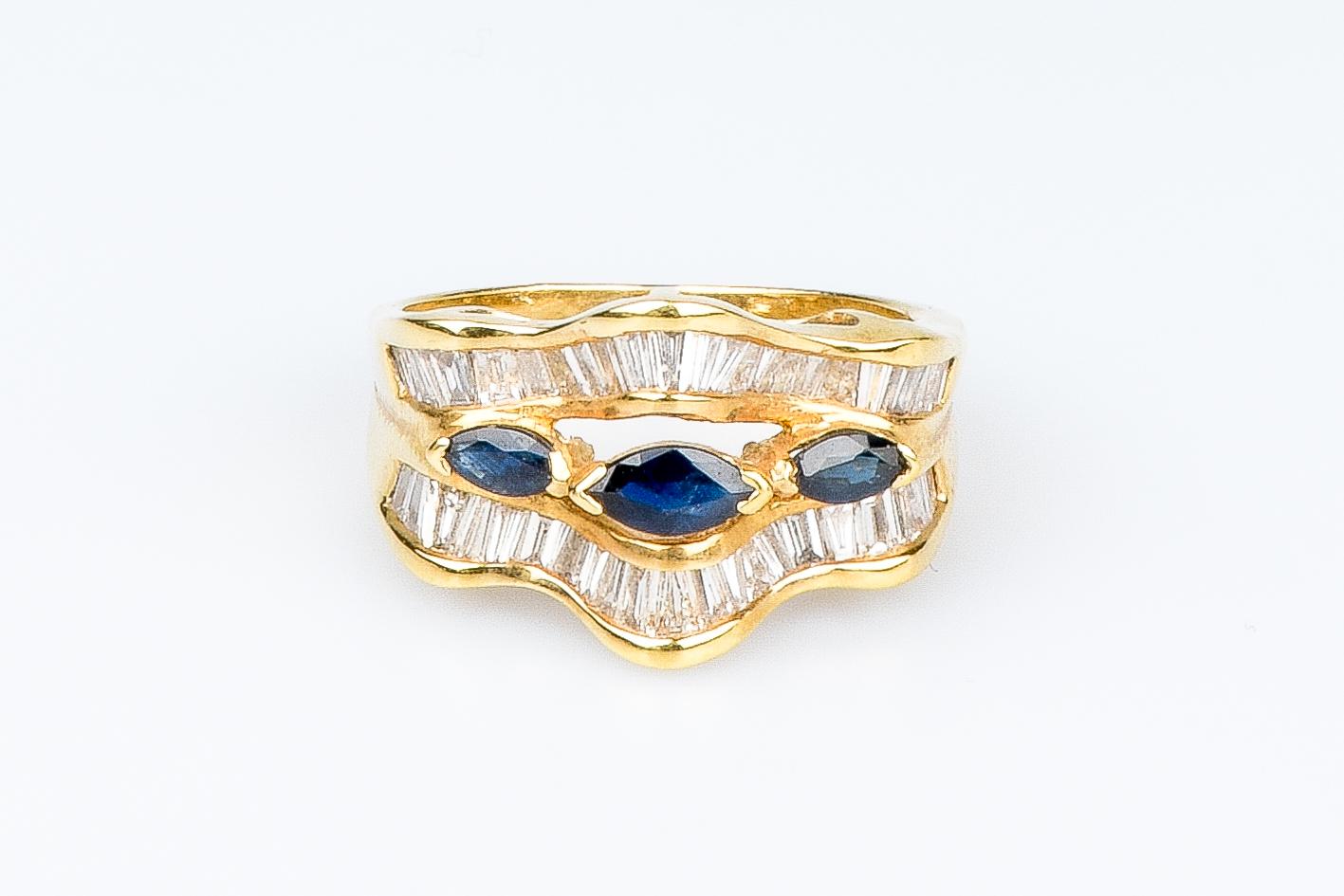 18 carat yellow gold ring designed with 1 shuttle sapphire weighing 0.24 carat, 2 shuttle sapphires weighing 0.26 carat and 48 round baguette cut diamonds weighing 1.44 carat.

Quality of the diamond:
Color : H
Clarity : SI

 Weight : 6.40 gr.
