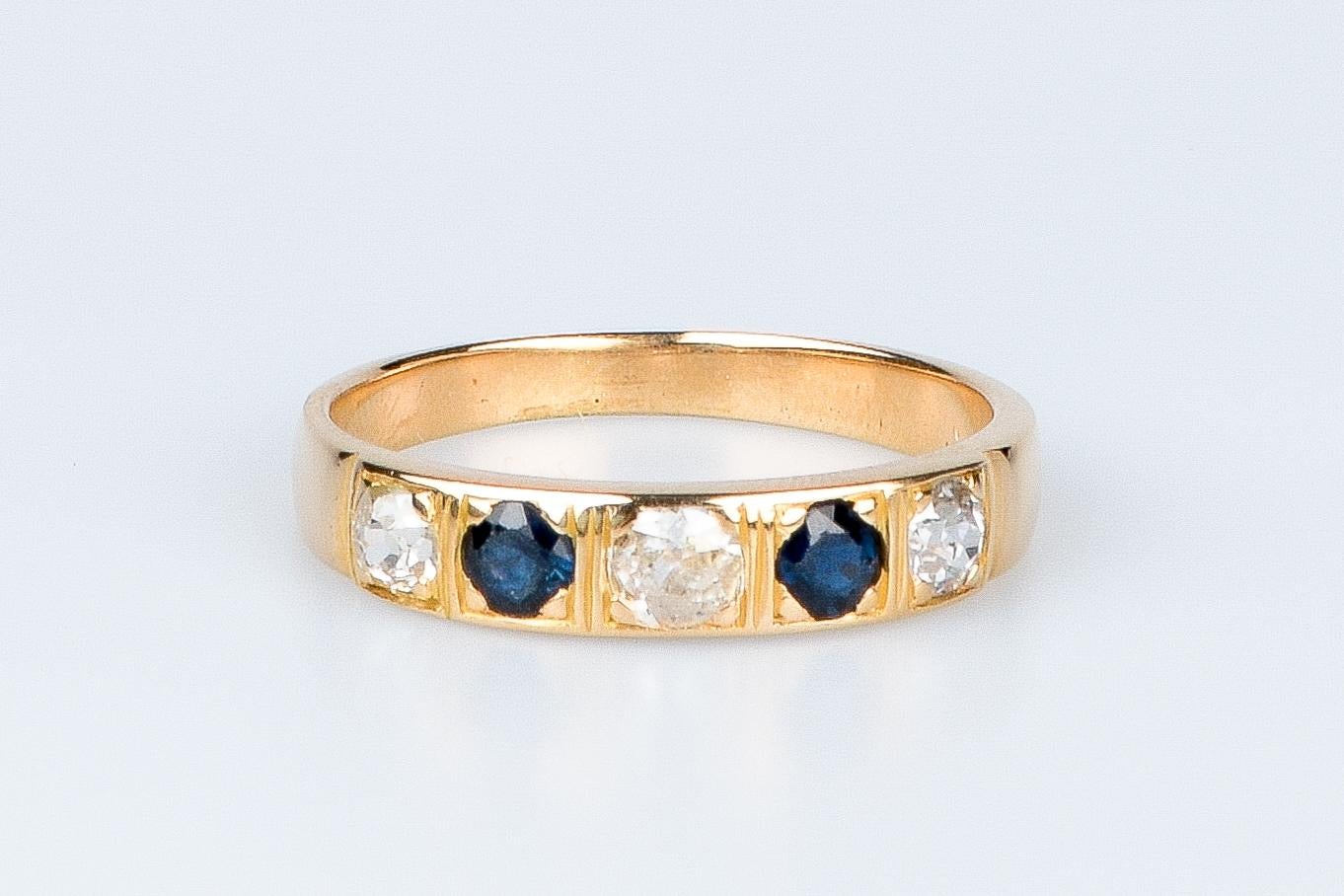 18 carat yellow gold ring designed with 3 round brilliant cut diamonds weighing 0.27 carat and 2 round sapphires weighing 0.12 carat.

Quality of the diamond
Color: H
Clarity: SI

Weight: 3.80 gr. 

Size: EU: 57 - ESP/IT: 17 - US: 8

Dimensions :