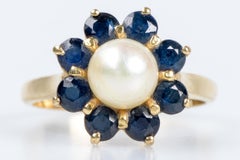 18-carat yellow gold ring with a flower-shaped head (8 sapphires and 1 pearl)