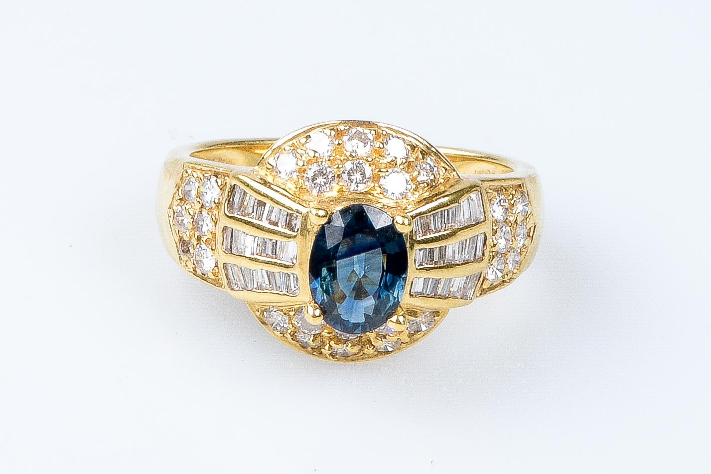 18 carat yellow gold ring designed with 1 oval sapphire weighing 1.06 carats, 30 baguette cut diamonds weighing 0.60 carats and 28 round brillant cut diamonds weighing 0.40 carats.

Quality of the diamond
Color : G
Clarity : VS

Weight : 5.78