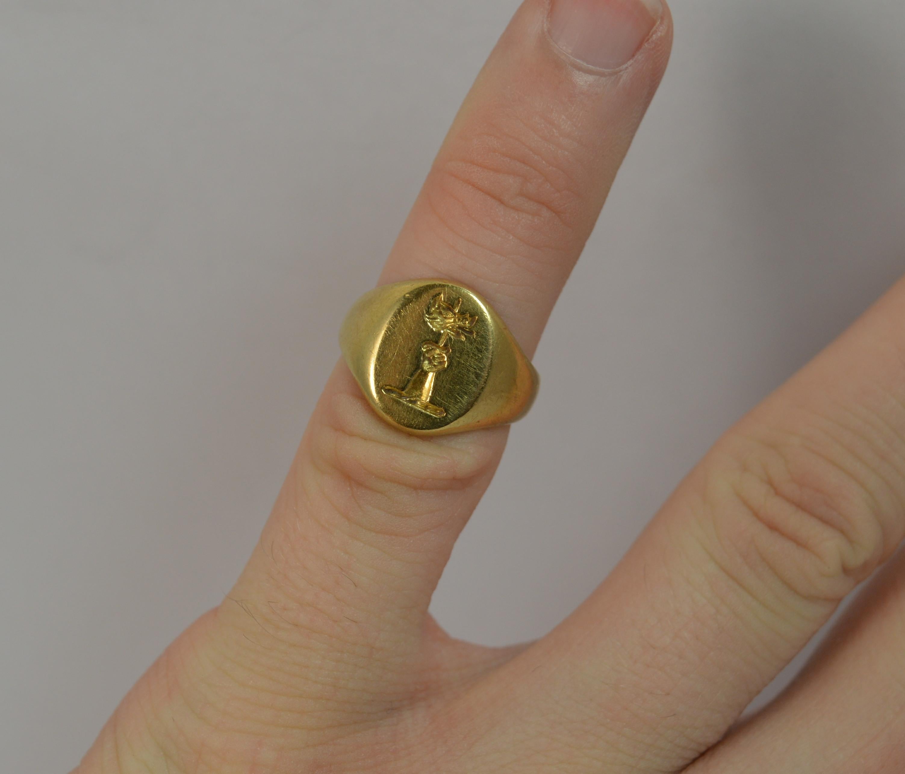 A stunning contemporary 18ct gold signet ring.
SIZE ; G UK, 3 1/4 US, sizeable
​The 10mm x 13mm oval head is expertly engraved with an arm and first reaching up with dagger in hand and boar head.

A solid and heavy 18 carat yellow gold