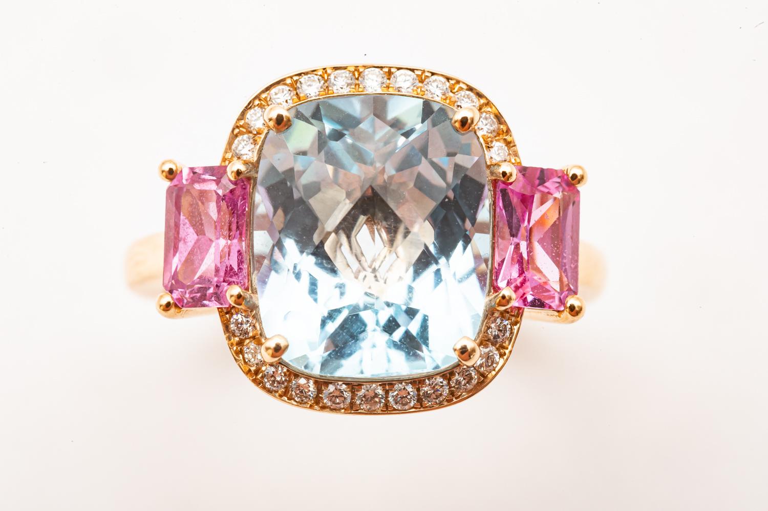 Discover the timeless elegance and sophisticated charm of this sumptuous 18K Yellow Gold Topaz, Pink Sapphire and Diamond Ring, which perfectly embodies the essence of the Art Deco style. Crafted with precision and adorned with three beautiful
