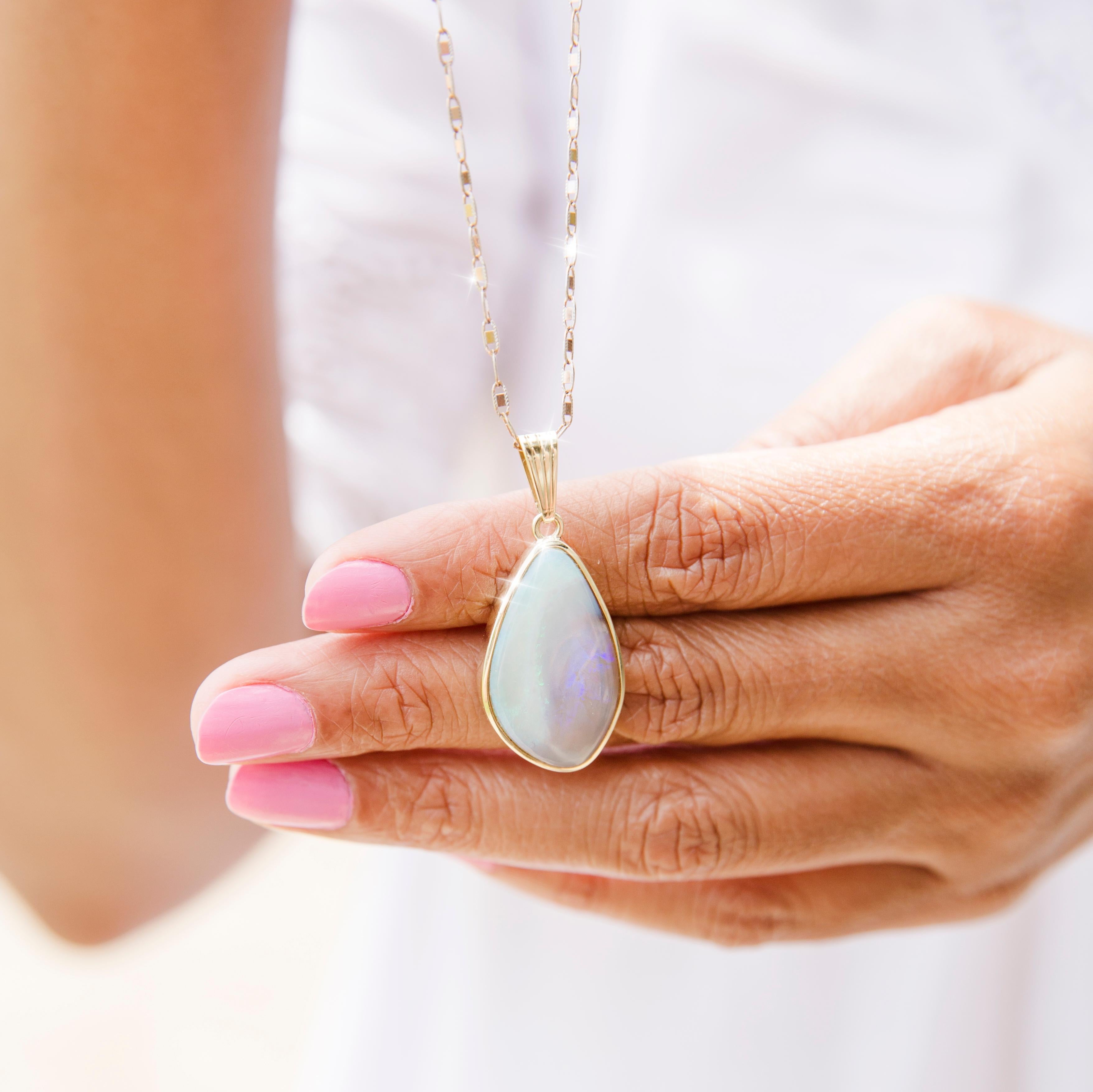 Lovingly crafted in 18 carat yellow gold, this charming vintage pendant features an enchanting free form triangular dark solid opal. The left side is of a light milky green colour with patches of red on the left, and the right side is a dark crystal