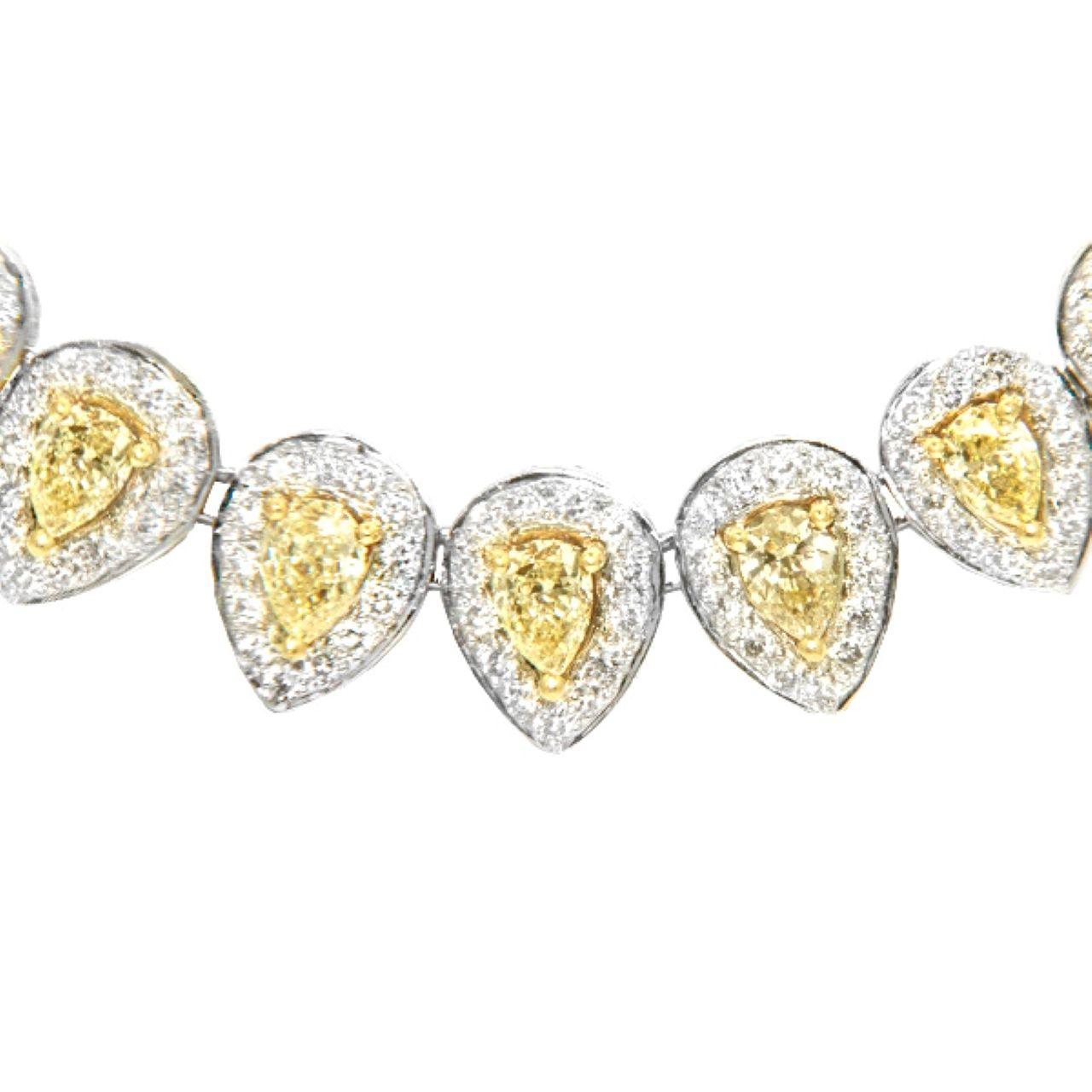 Ti presentiamo una squisita collana di diamanti Fancy Yellow Pear Cut certificata IGI e impreziosita da 54 diamanti fancy yellow a forma di pera per un totale di 11,86 carati. Ogni diamante abbagliante è elegantemente circondato da un'aureola di