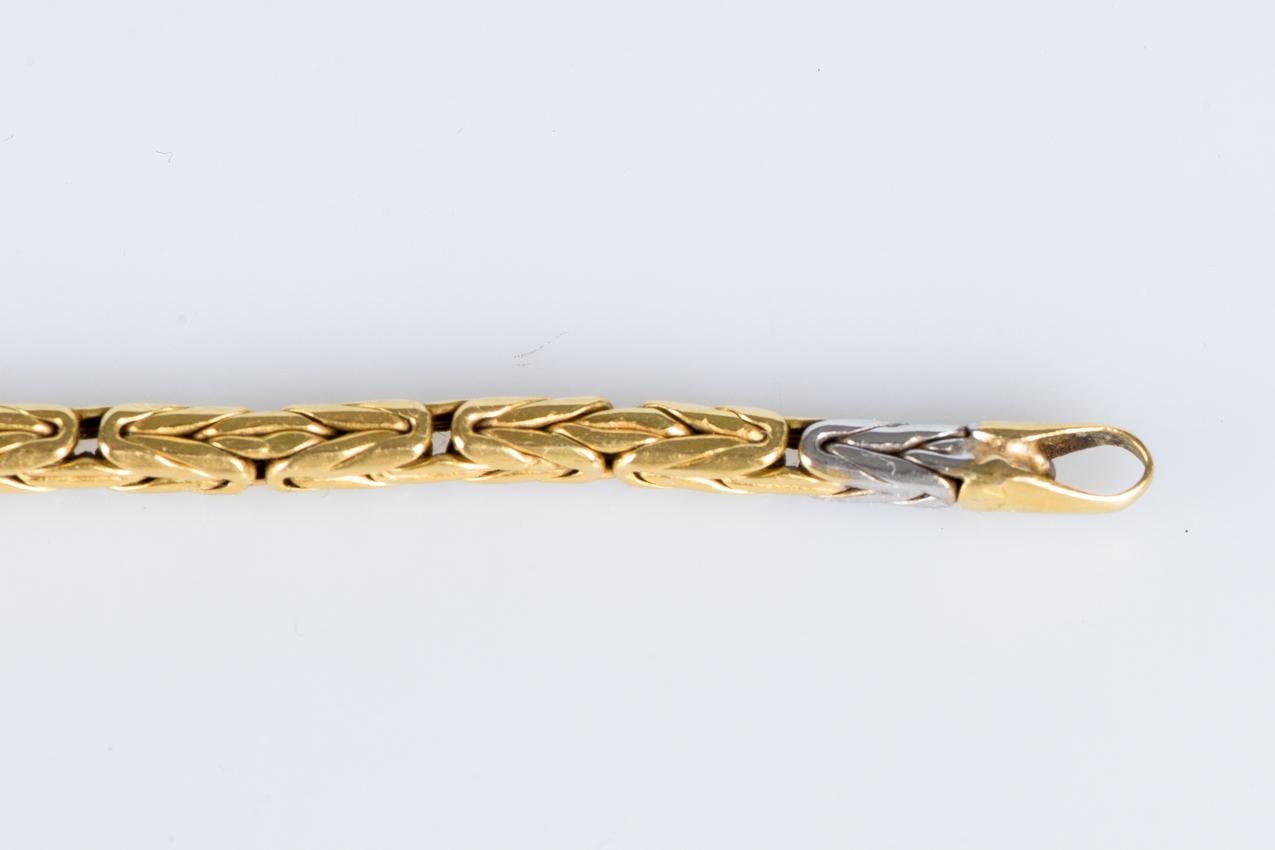 Whiting en or blanc et jaune 18 carats. 

Composé de deux ors différents dans un motif en quinconce de 6 maillons. 

Fermoir classique pour le style et la fonctionnalité dans une pièce qui incarne l'essence du luxe moderne.

Célébrez l'élégance avec