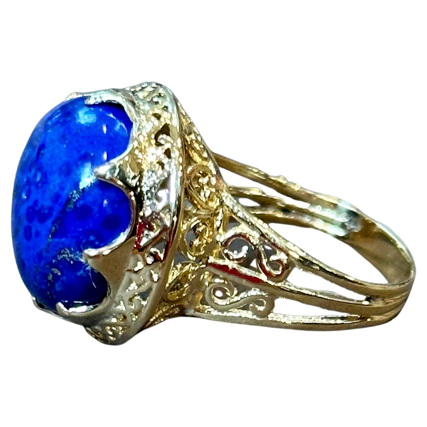 Vintage Beautiful  Filigree Ring in 14 Karat yellow gold 
This is a ring which has a 18 carat of high quality natural Lapis  Lazuli Cabochon , Round in shape 
Color , Cut and clarity is very nice.

14 K Yellow gold 9.33 grams
Ring Size 9.5 but can