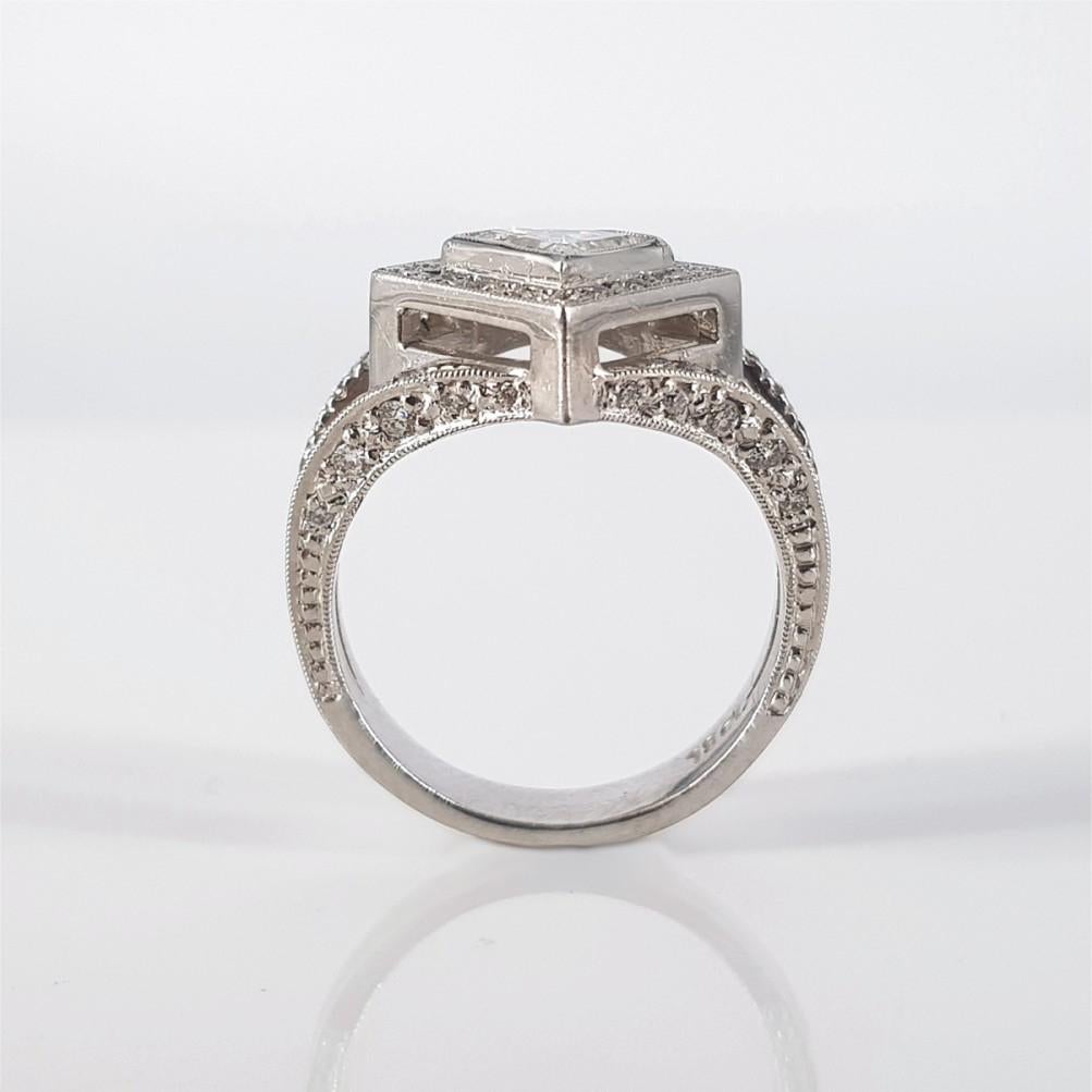 Strong, striking and pronounce, this ring says it all. Set in 18carat white gold and weighing 7.5 grams, this ring features a Shield Cut Diamond weighing 0.96 carat of J/i1 quality and 78 RBC Diamonds (GH vs-si) weighing 0.39 carat in total. The