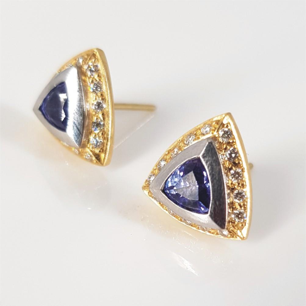 This Classy and Sophisticated pair of studs are set in 18Carat yellow and white Gold weighing 7.6 grams. They feature 2 Triangular Cut Tanzanite’s weighing 1 carat in total and 30 RBC Diamonds weighing 0.15 carat in total. Diamonds are GH in Colour